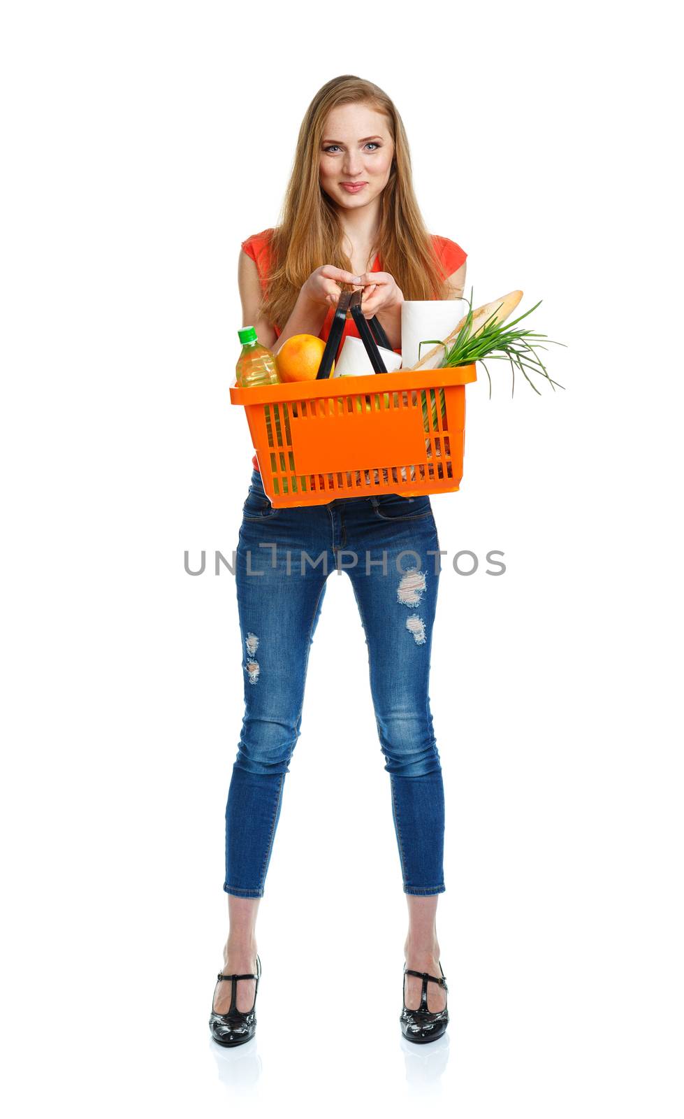 Happy young woman holding a basket full of healthy food. Shopping