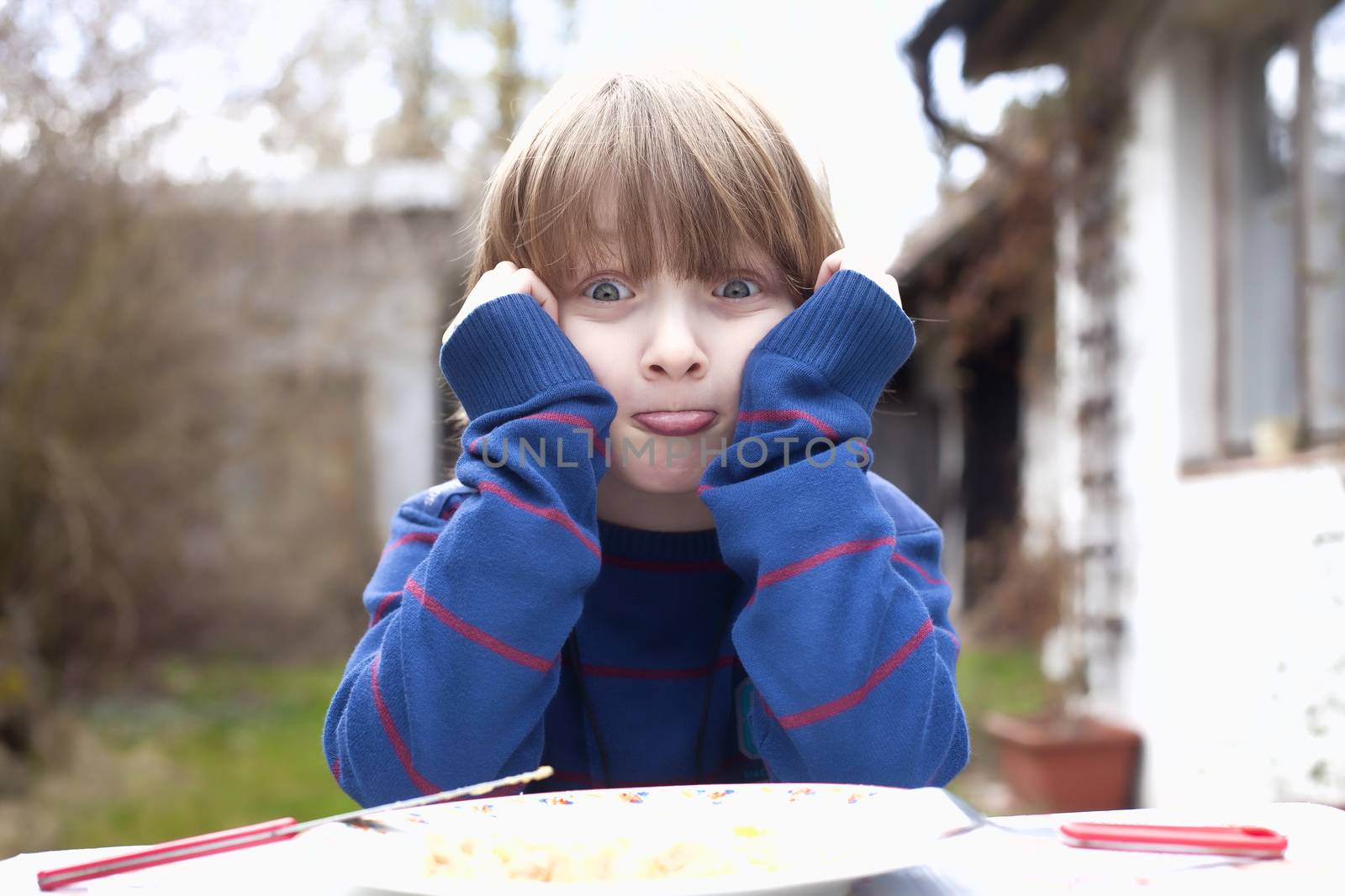 Boy Eating Outdoors Making Faces