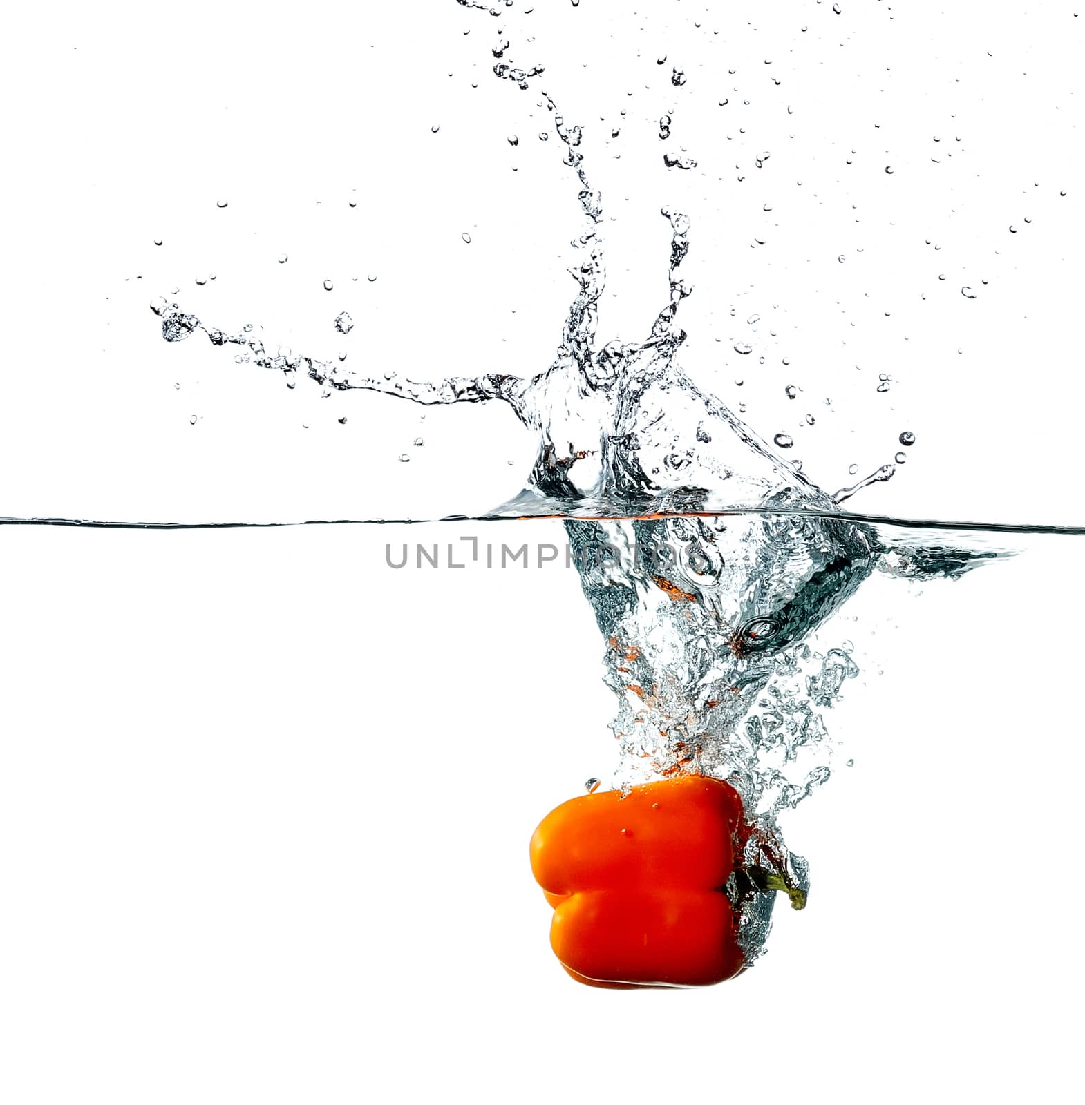 Fresh red pepper drops into a water, isolated on white background