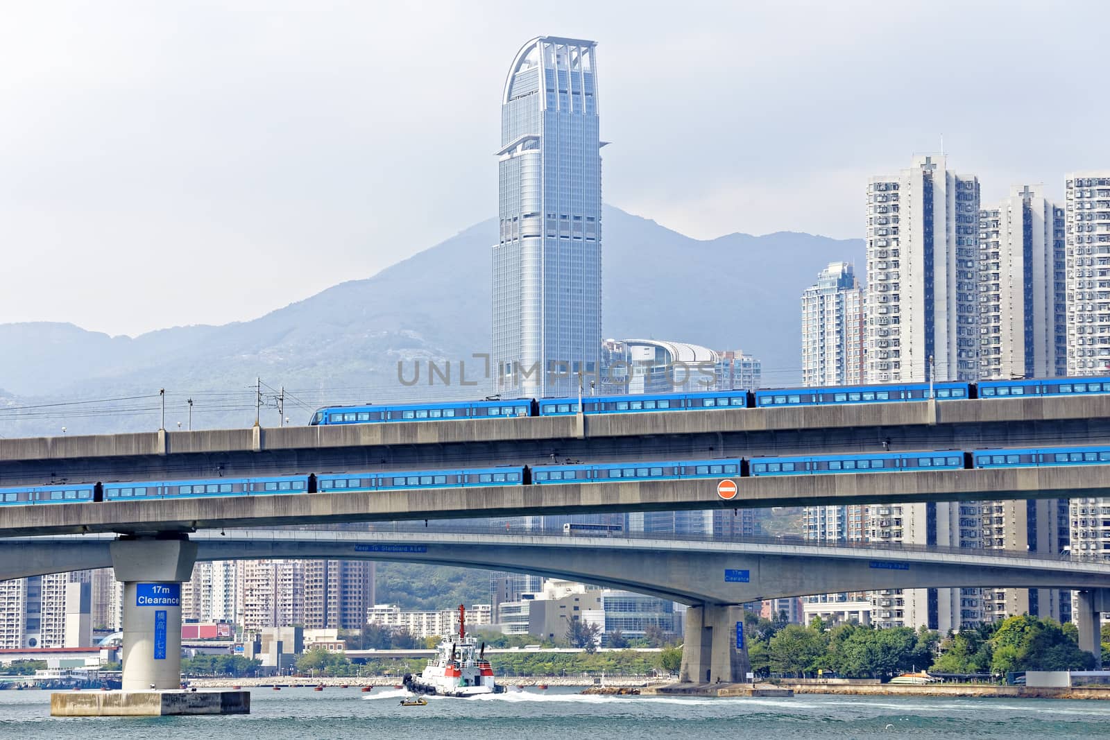 high speed train on bridge in hong kong downtown city at day