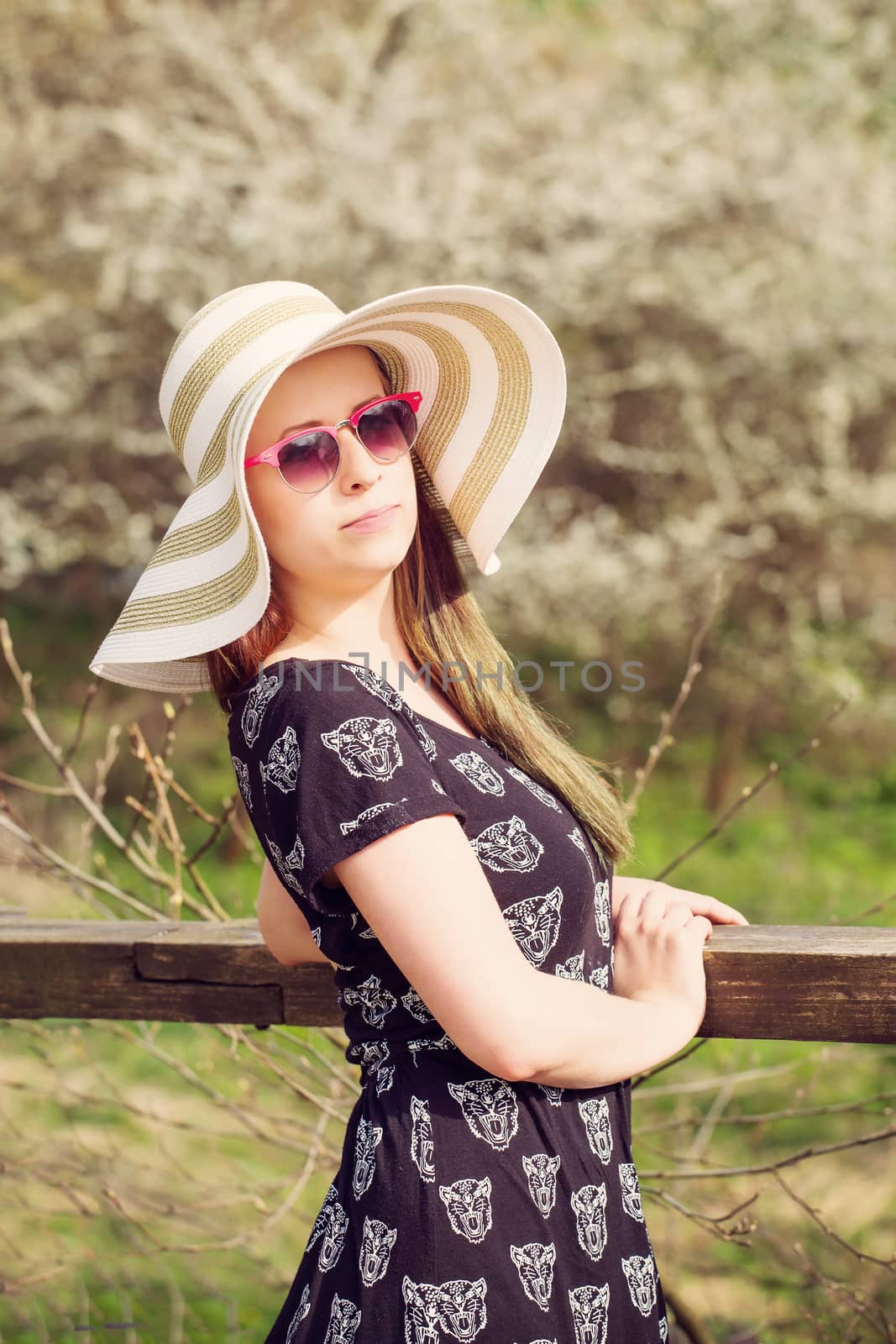Cheerful fashionable woman in stylish hat, frock and sunglasses by artush