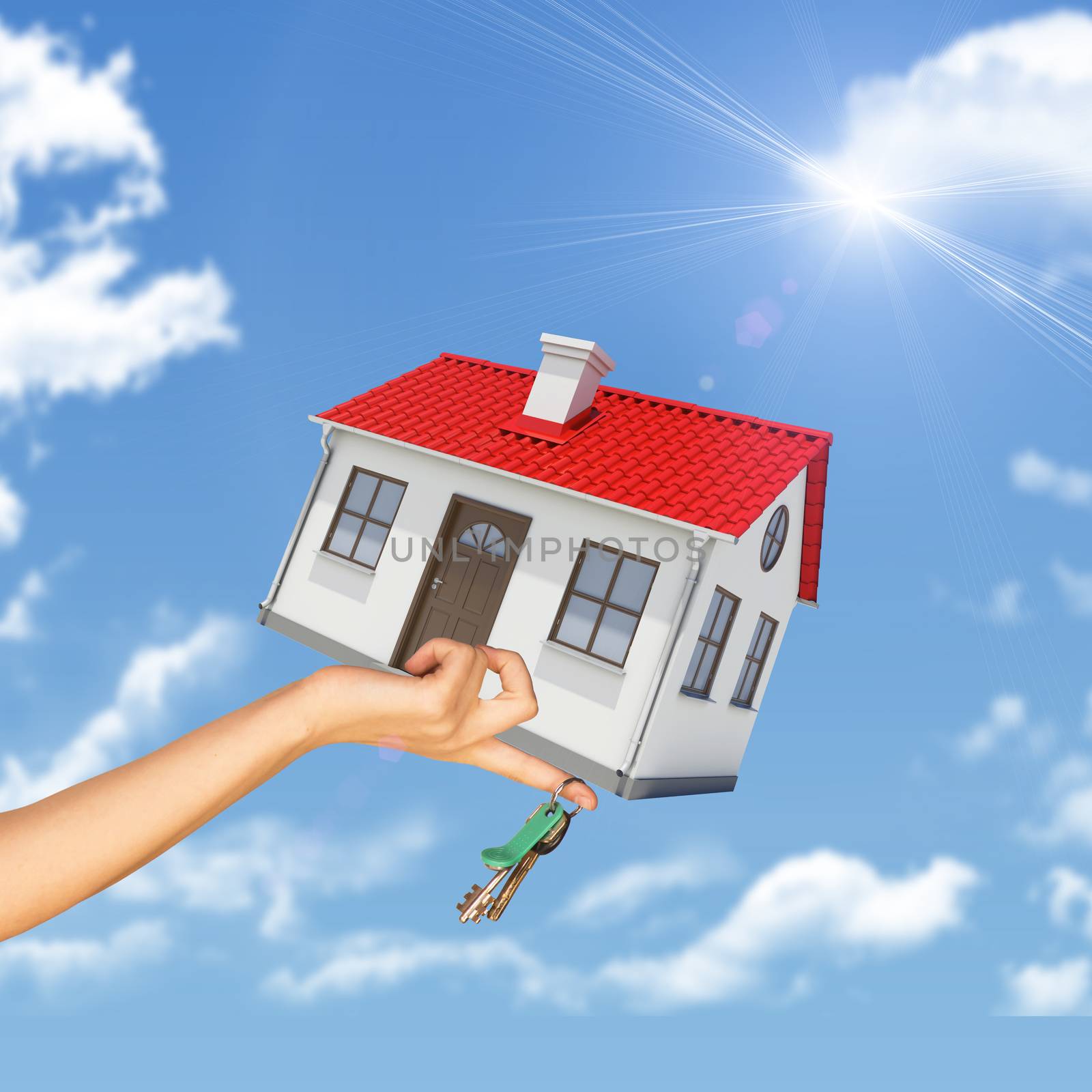House and keys in womans hand on blue sky background 