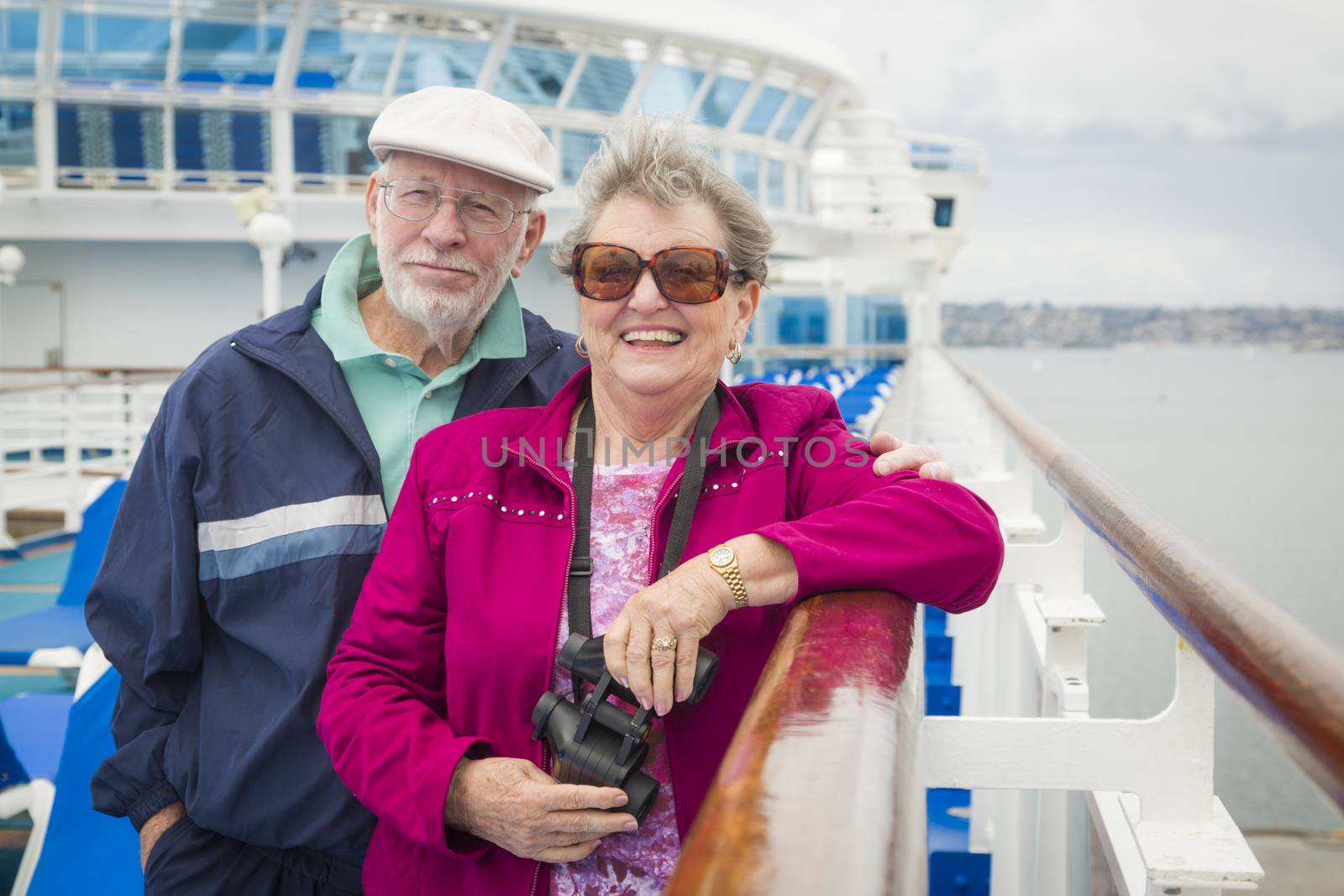 Happy Senior Couple Enjoying The View From Deck of a Luxury Passenger Cruise Ship.