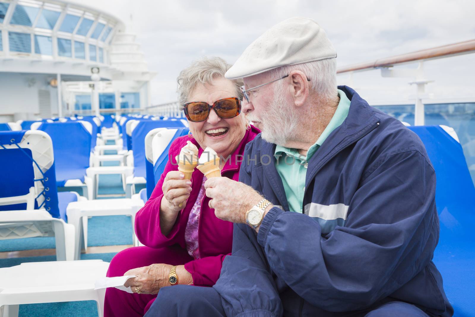 Senior Couple Enjoying Ice Cream On Deck Of Cruise Ship by Feverpitched