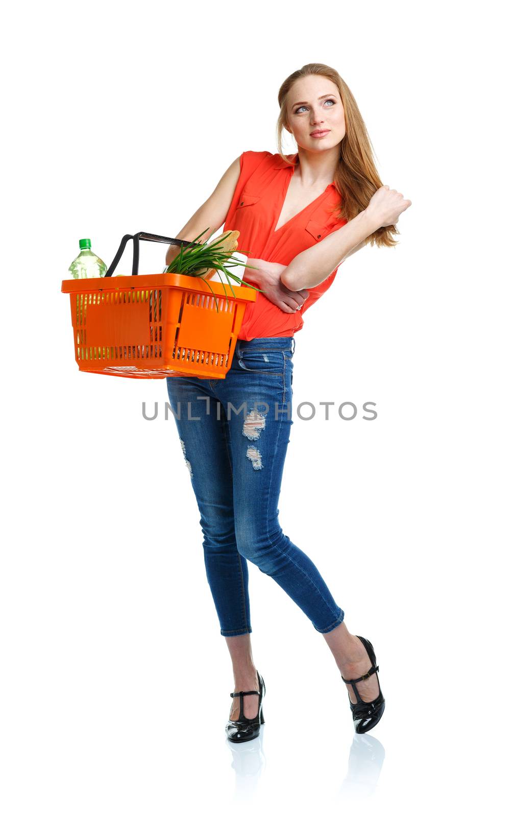 Happy young woman holding a basket full of healthy food. Shopping