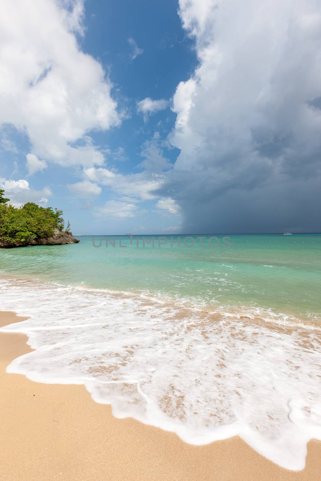 Beach on the tropical island. Clear blue water, sand and clouds. Beautiful vacation spot.