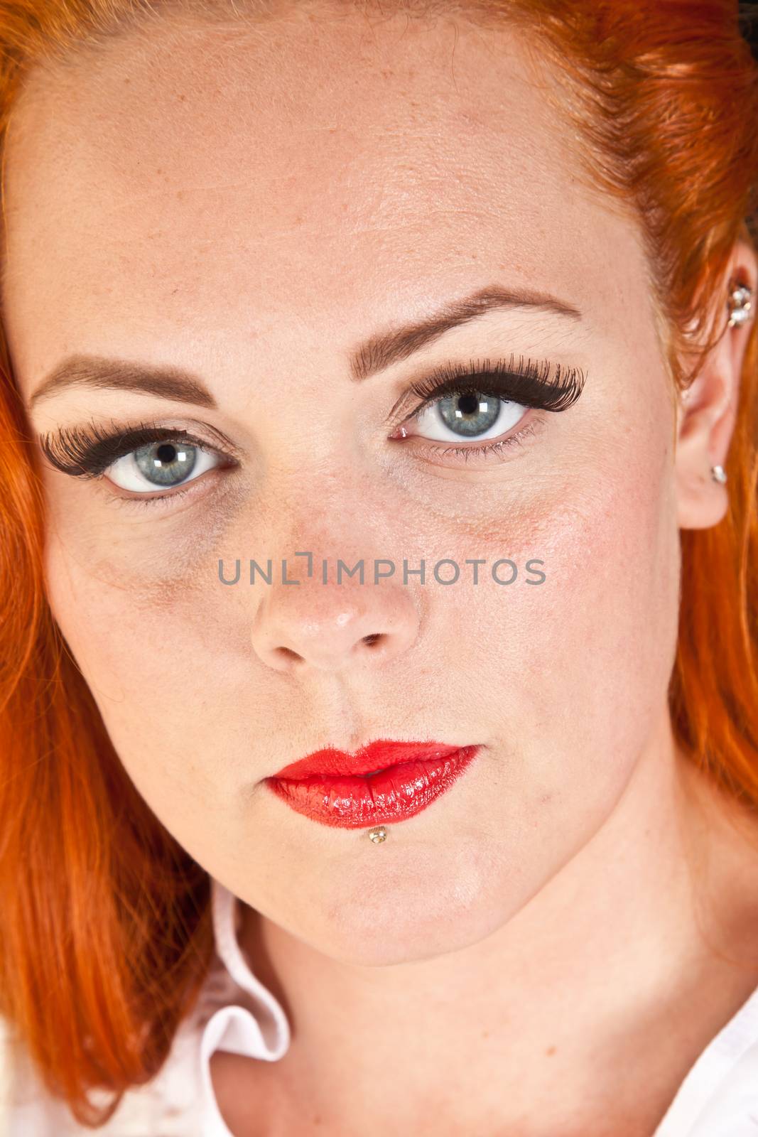 Red hair girl in pin-up style portrait shot in studio by jeancliclac