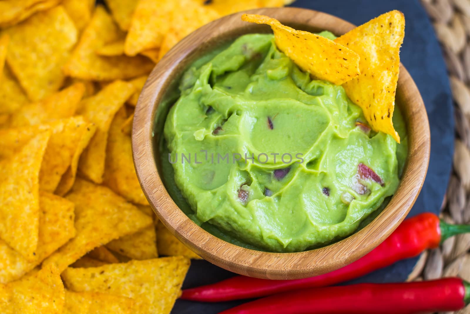Guacamole in Wooden Bowl with Tortilla Chips and Chilli