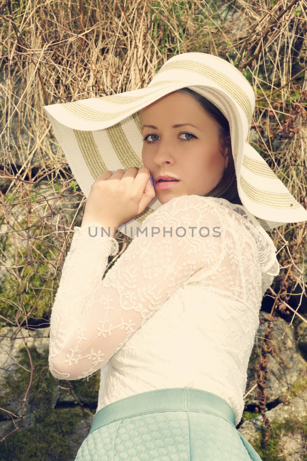 Cheerful fashionable woman in stylish hat and frock posing by artush