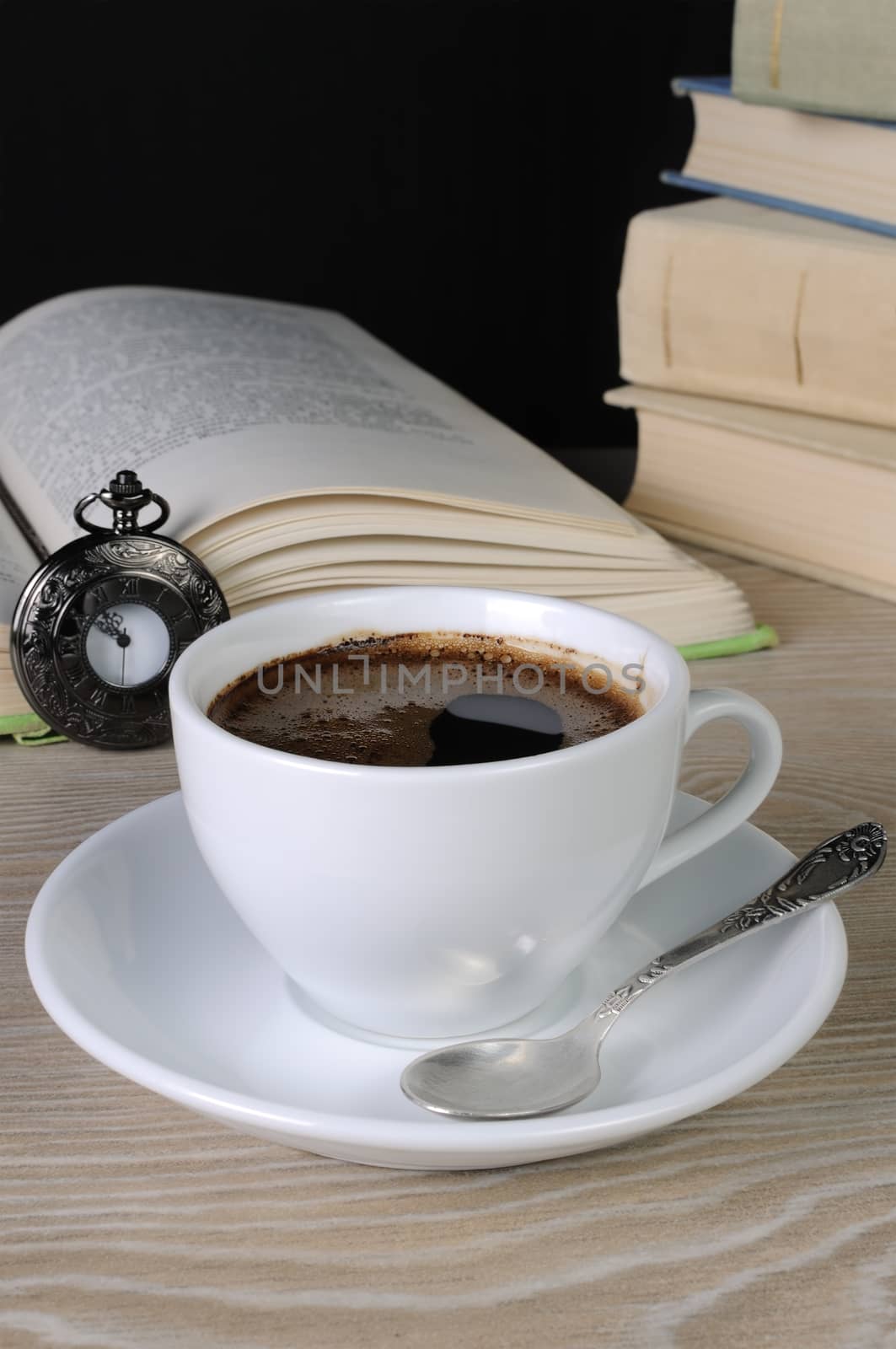 freshly brewed cup of fragrant coffee on a table among books