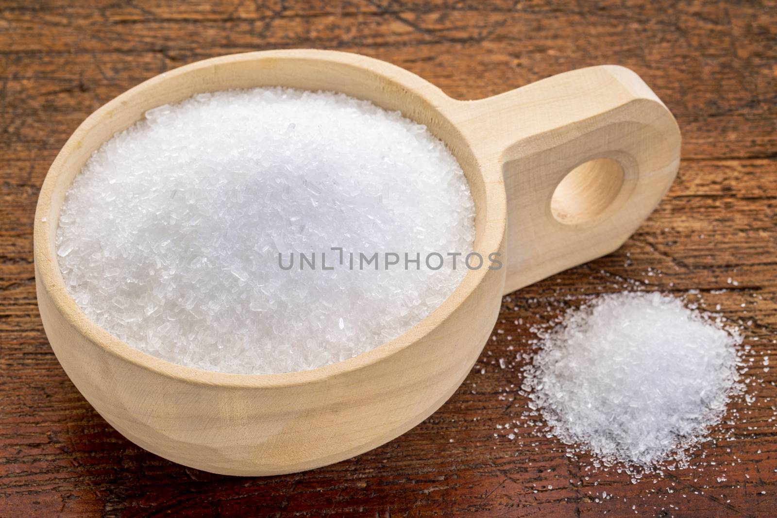 Magnesium sulfate (Epsom salts) in a rustic wooden scoop - relaxing bath concept