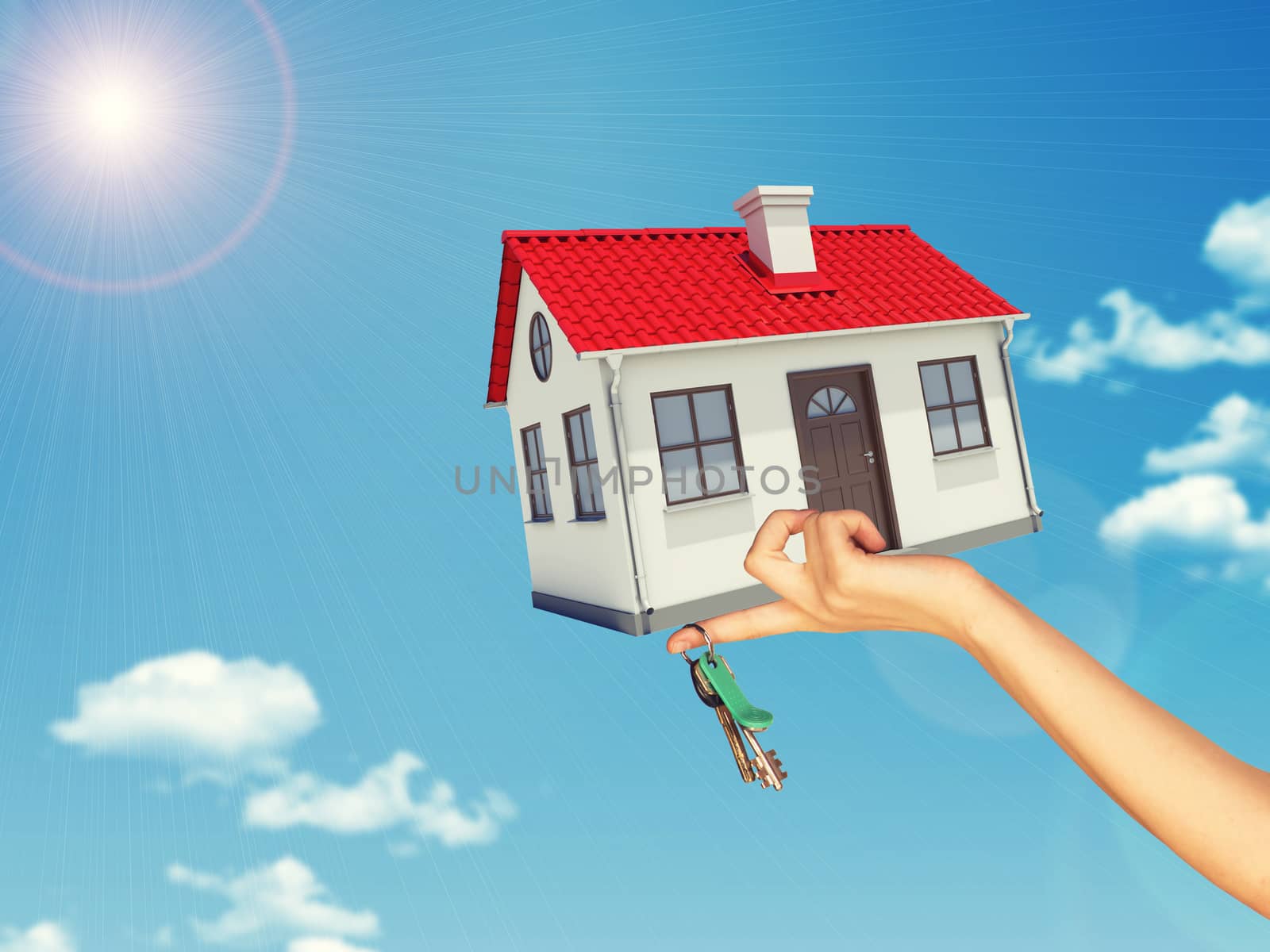 House and keys in womans left hand on blue sky background 