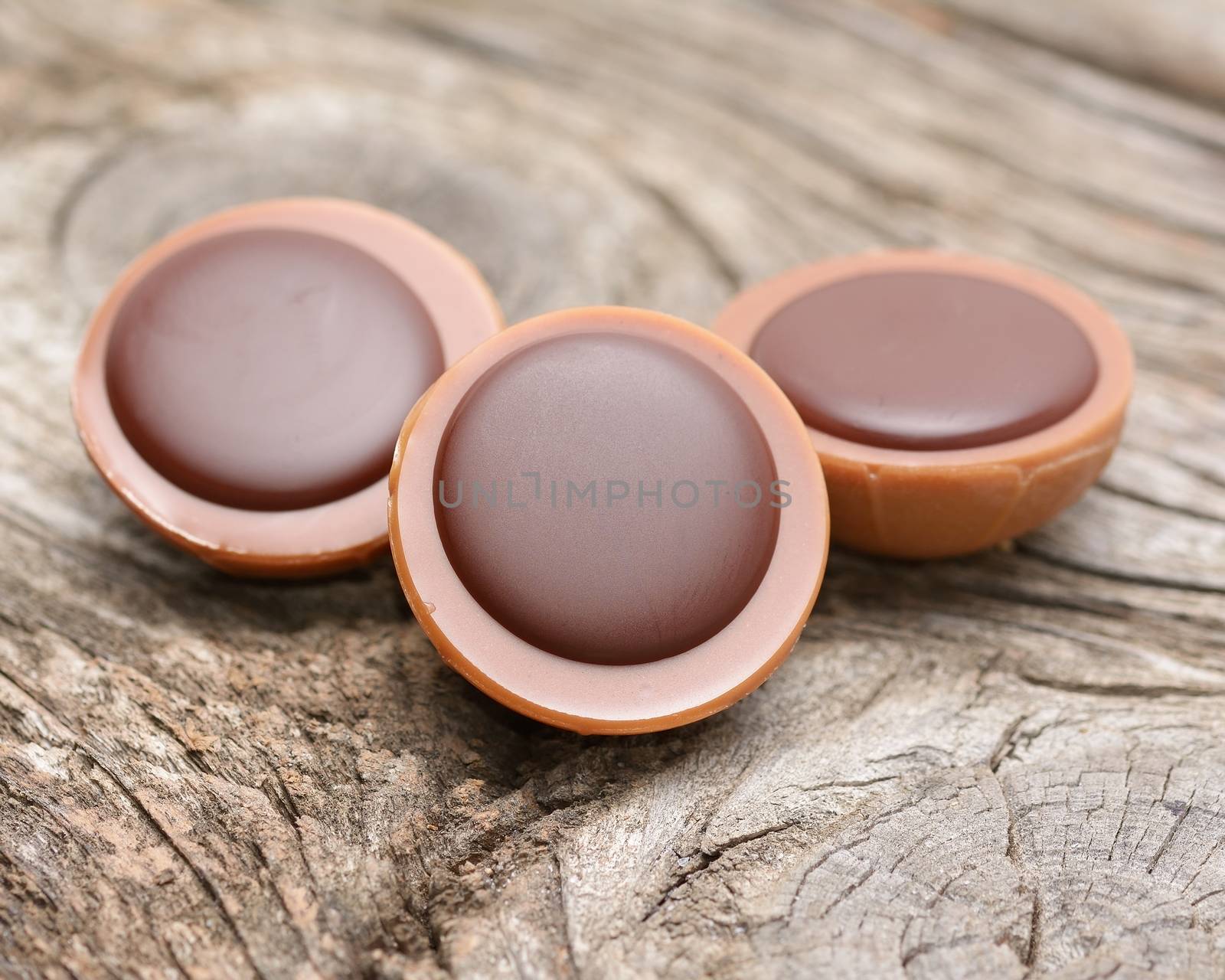 A hazelnut in caramel with creamy nougat and chocolate on wooden background