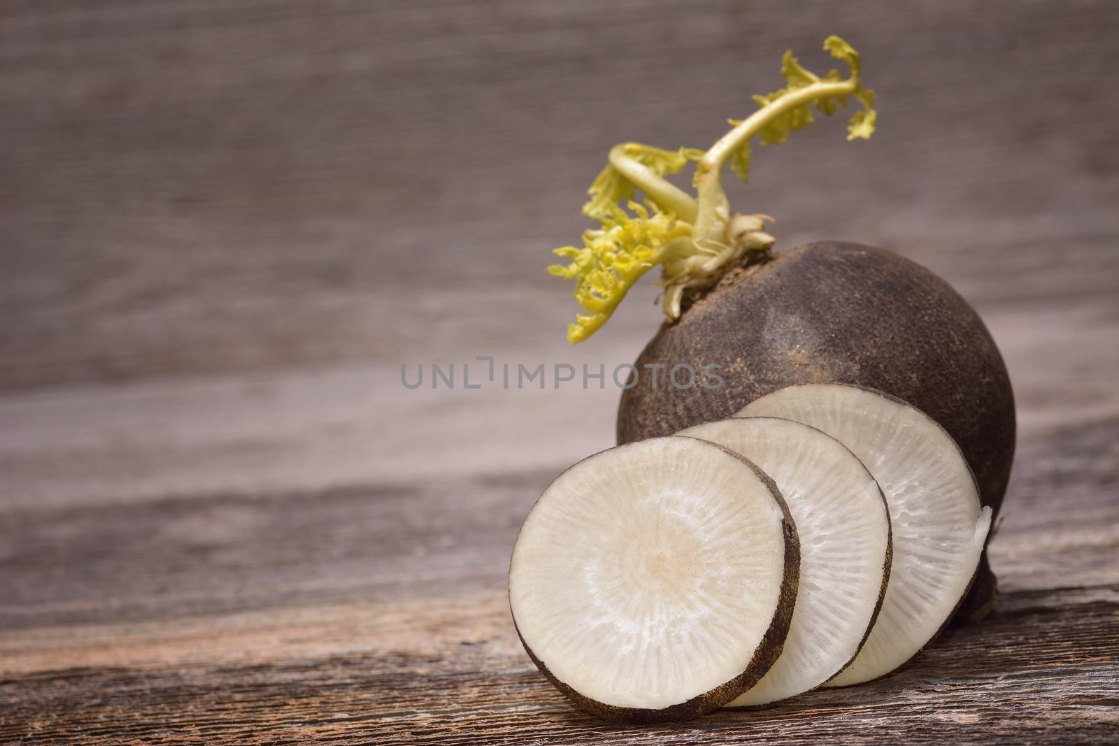 Black radish on wooden background by comet