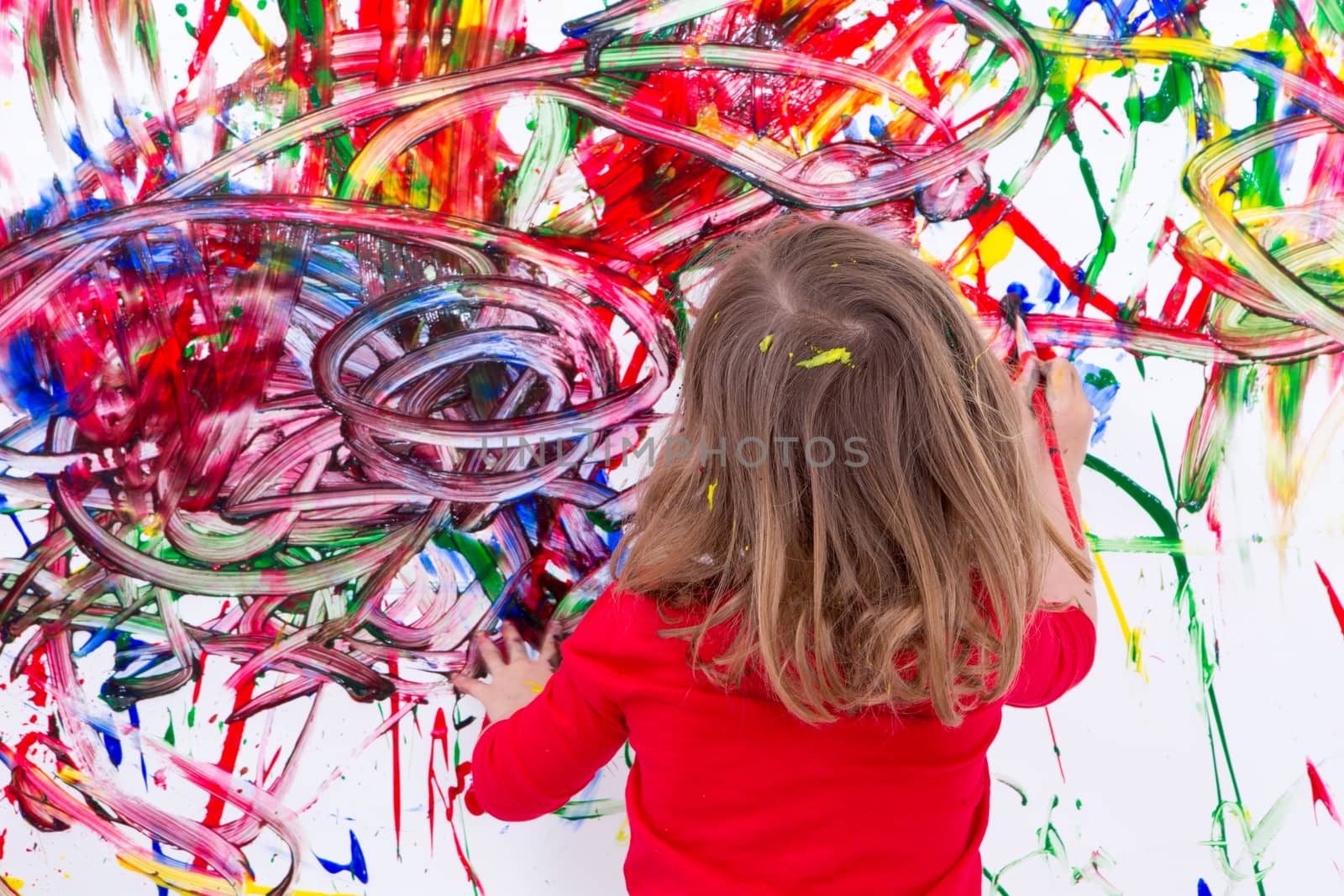 Young Kid Painting Abstract on White Wall by coskun