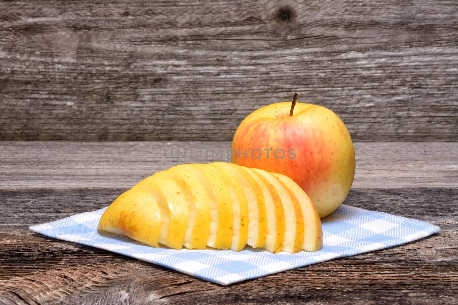 Whole and Cut in Half Apple on Textured Weathered Wooden Table by comet