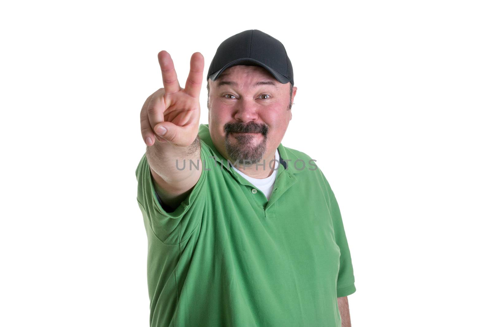 Portrait of Overweight Man with Goatee Wearing Green Shirt and Black Baseball Cap Smiling and Giving Peace Sign Hand Gesture Toward Camera, on White Background