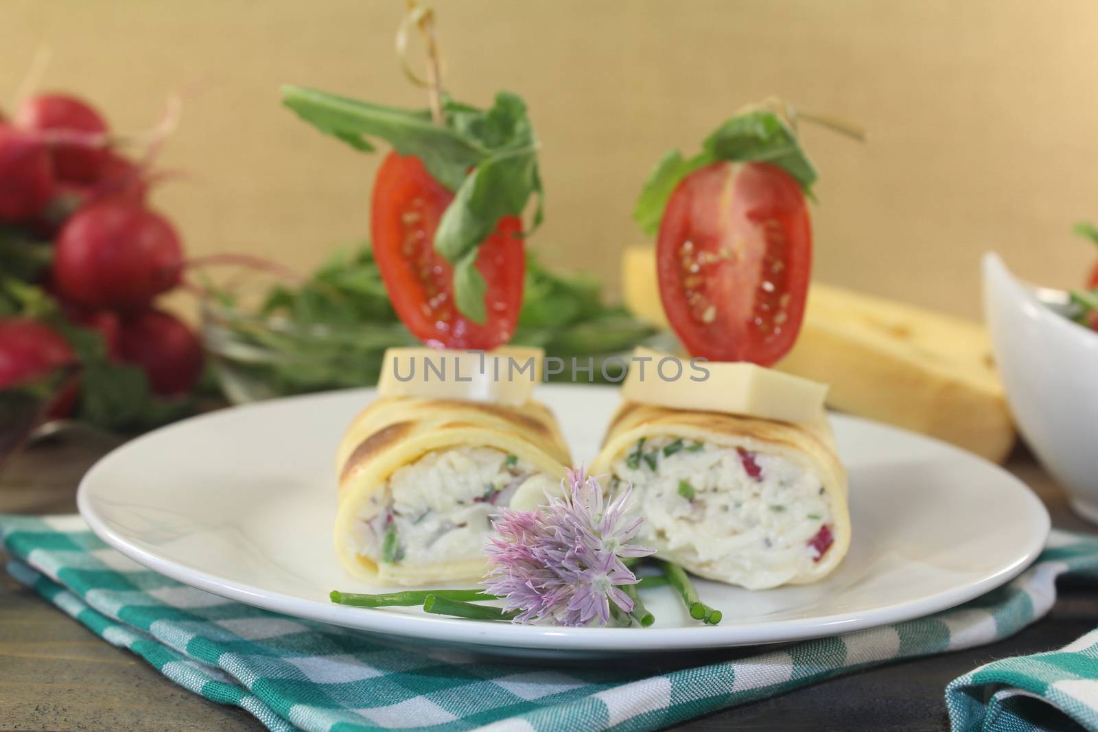 stuffed cheese crepe rolls with tomatoes and arugula