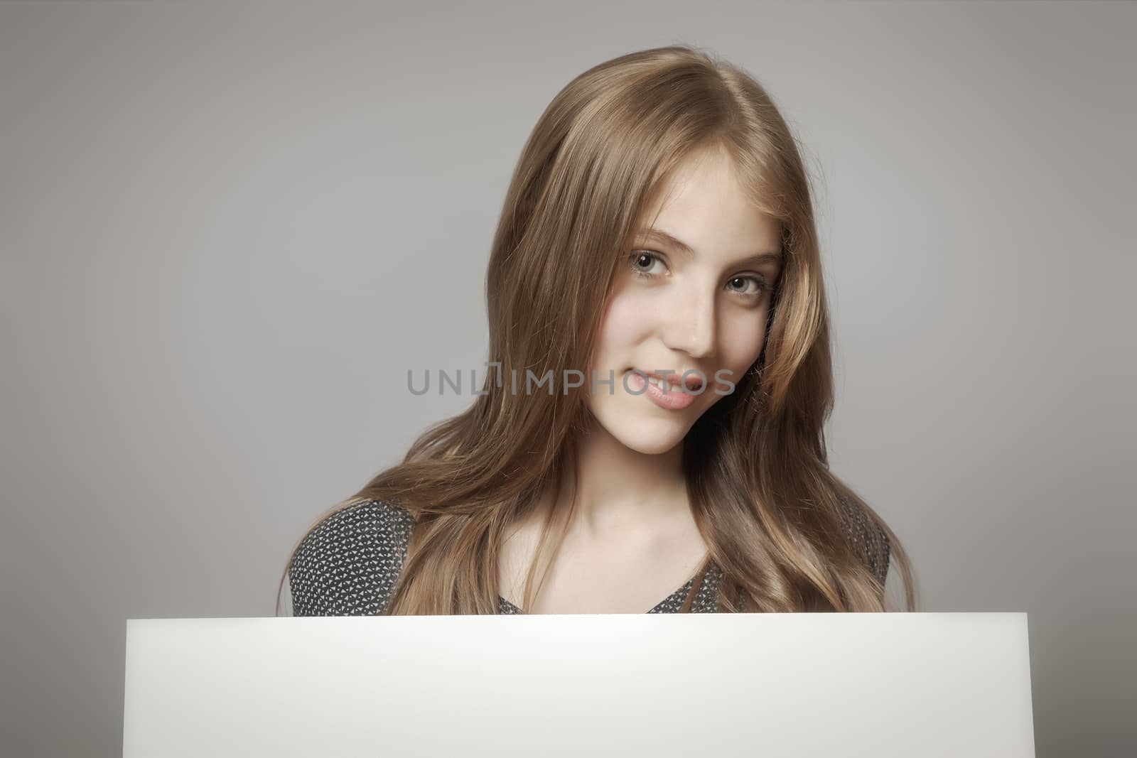 An image of a beautiful teenage girl holding a white board