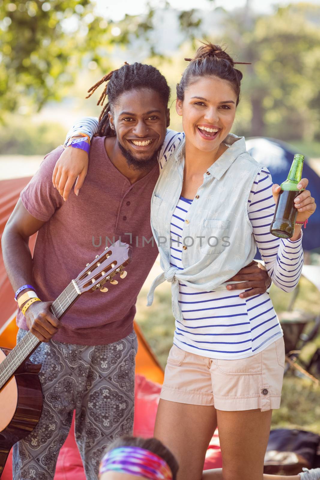 Happy hipsters having fun on campsite at a music festival 