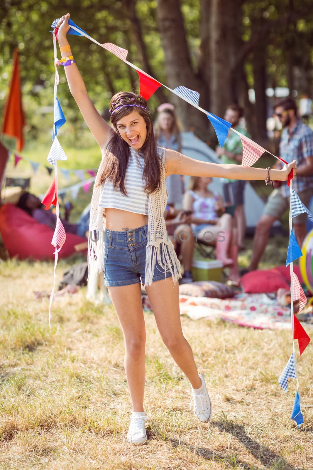 Pretty hipster posing for camera with flags at a music festival 