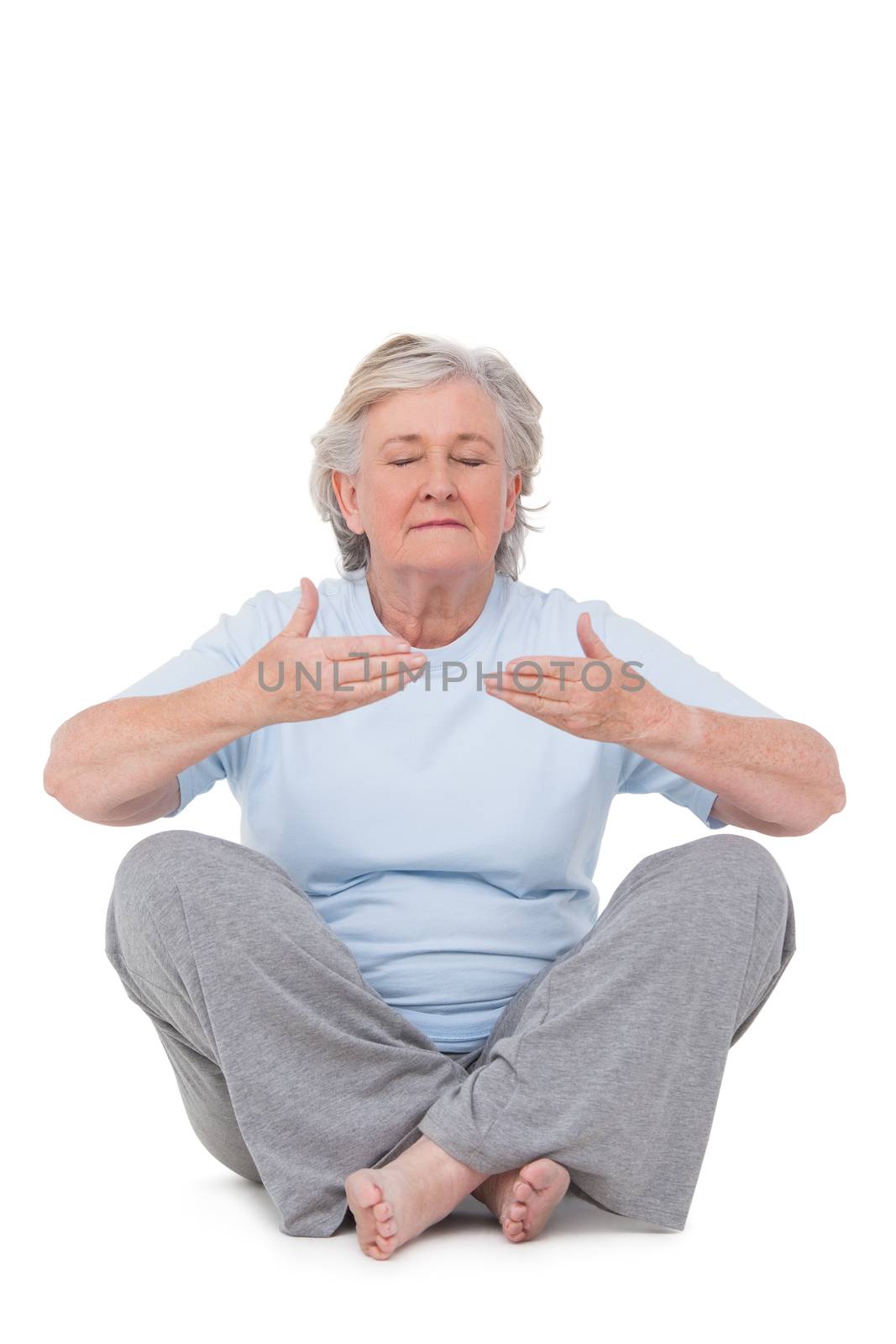 Senior woman doing yoga exercise on white background