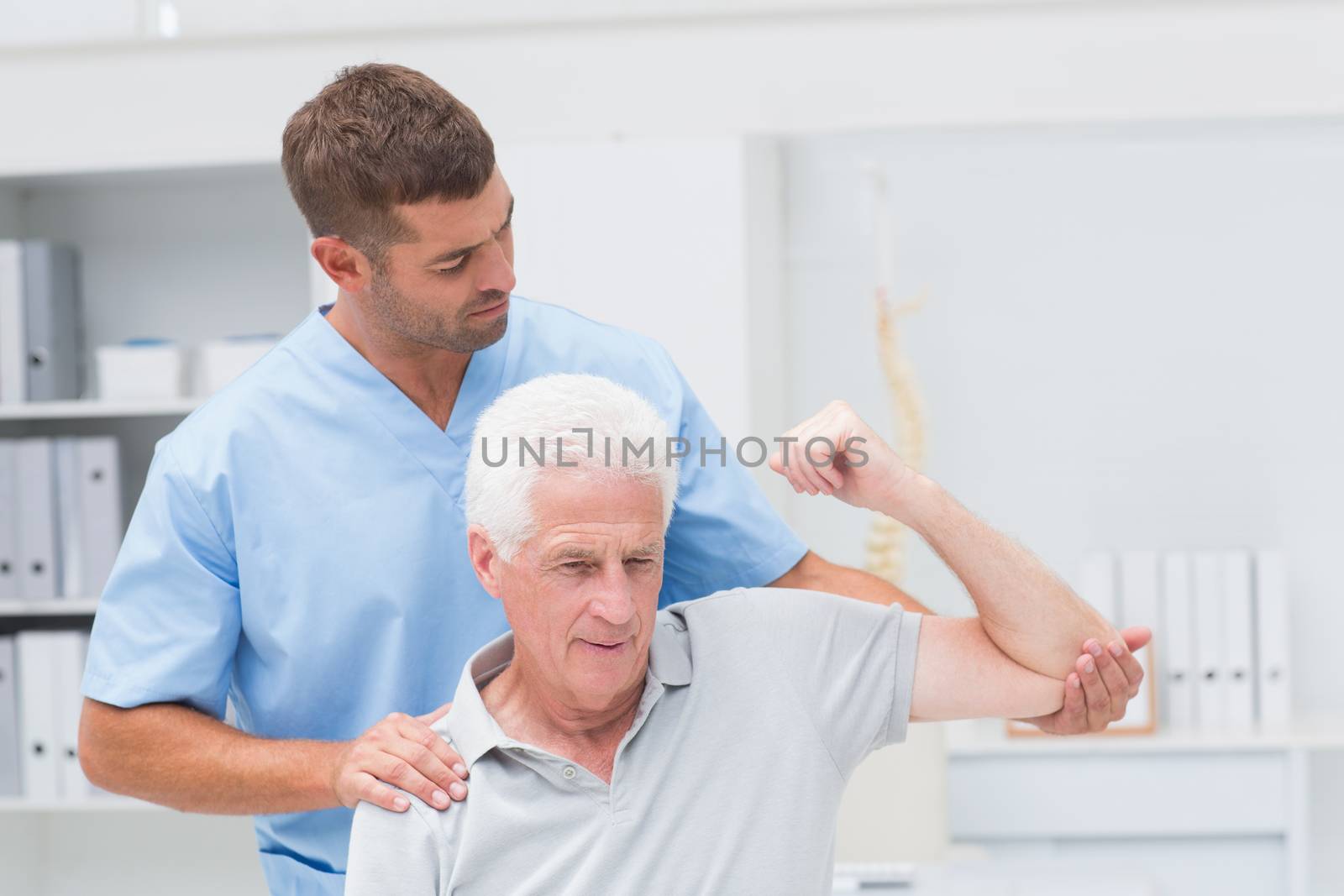 Physiotherapist giving physical therapy to man by Wavebreakmedia