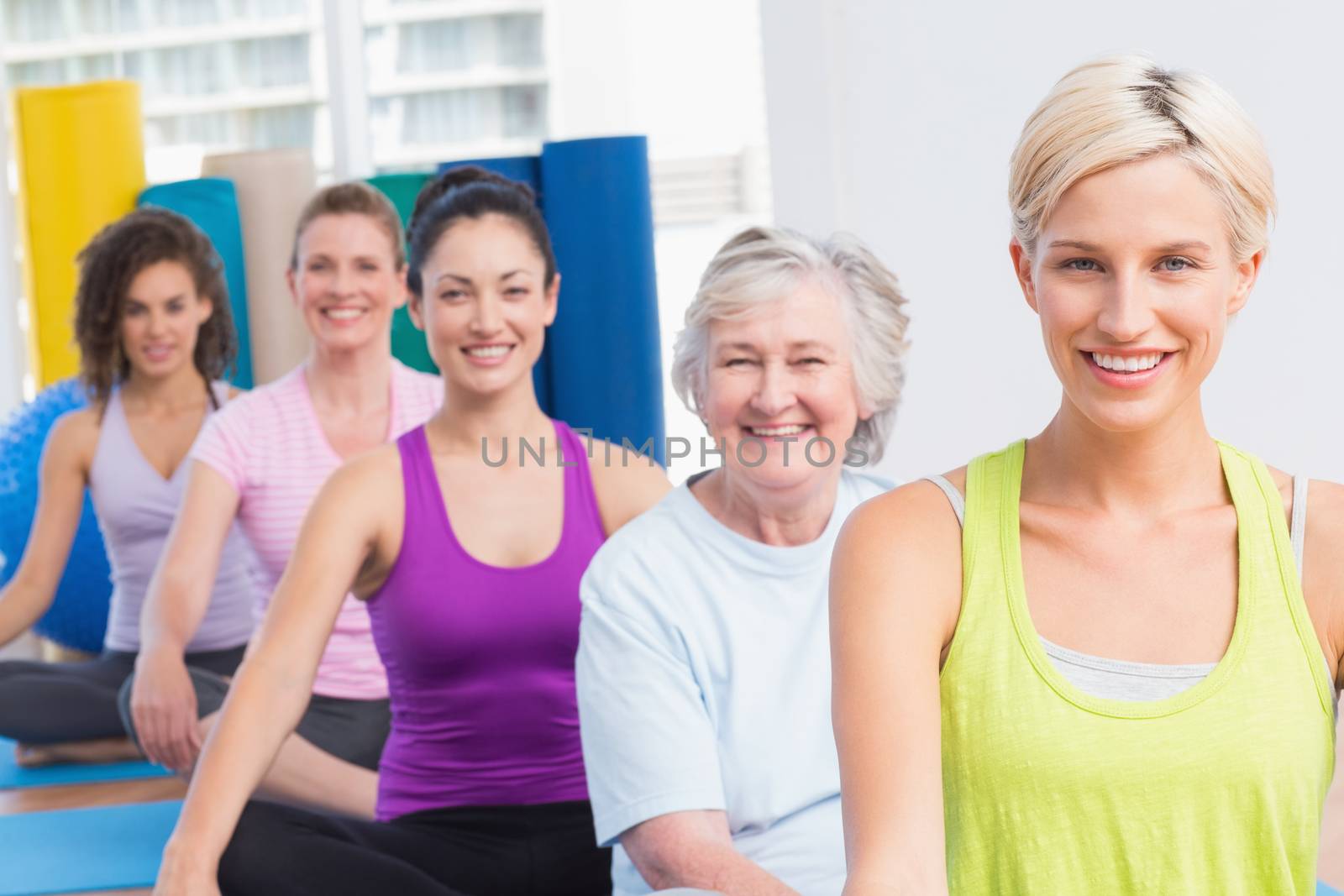 Portrait of happy fit women practicing yoga during fitness class 