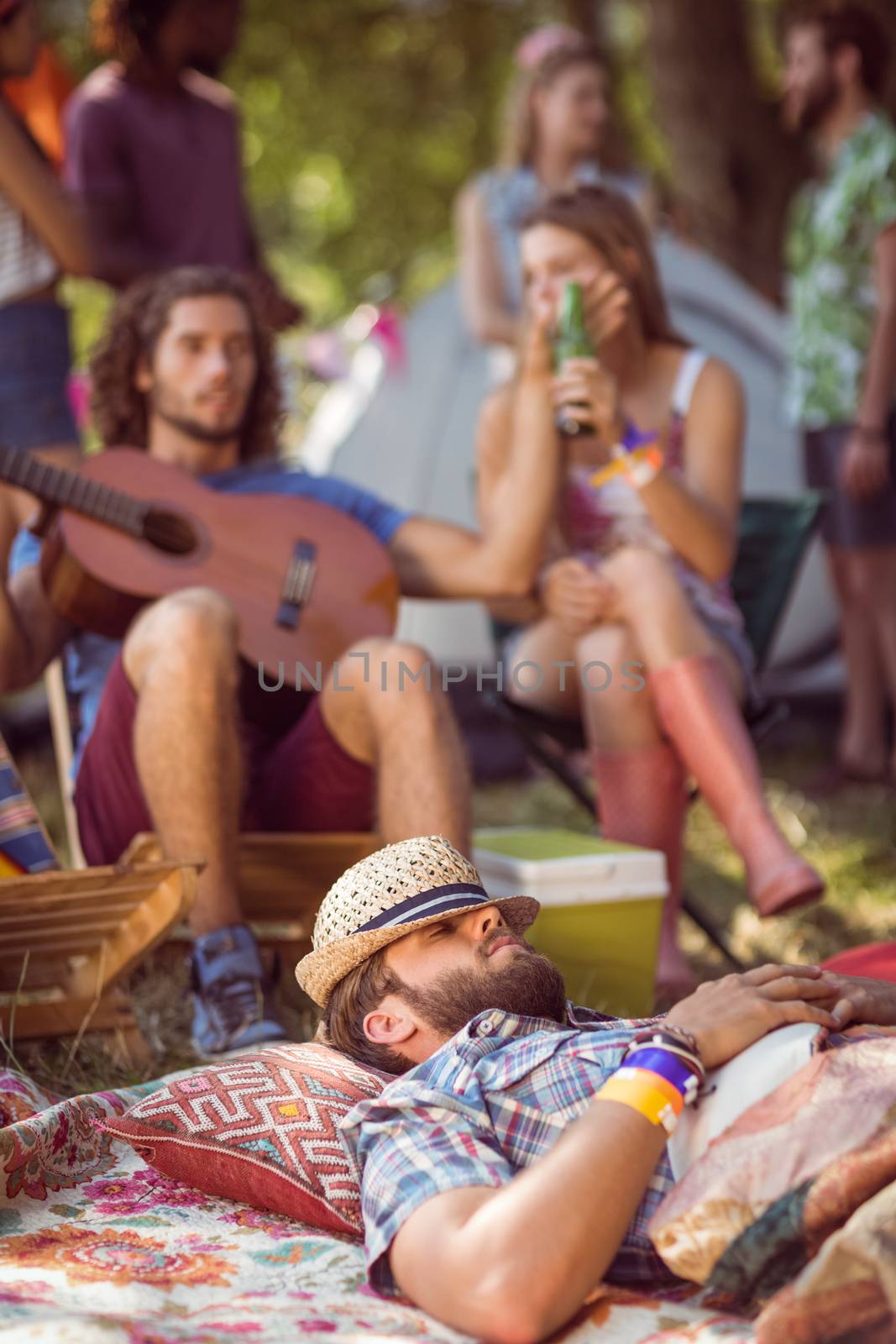 Handsome hipster relaxing on campsite at a music festival 