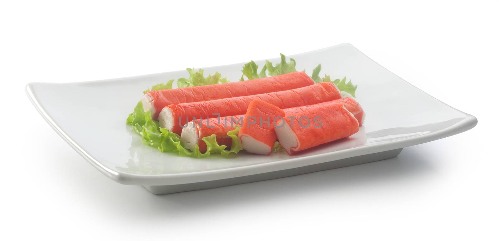 Some red crab stick with green lettuce on the white plate