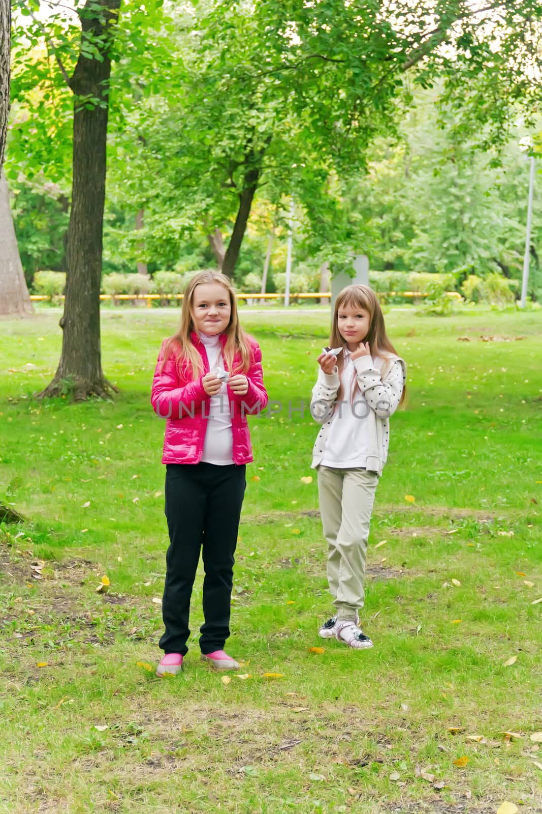 Photo of two eating girls in summer