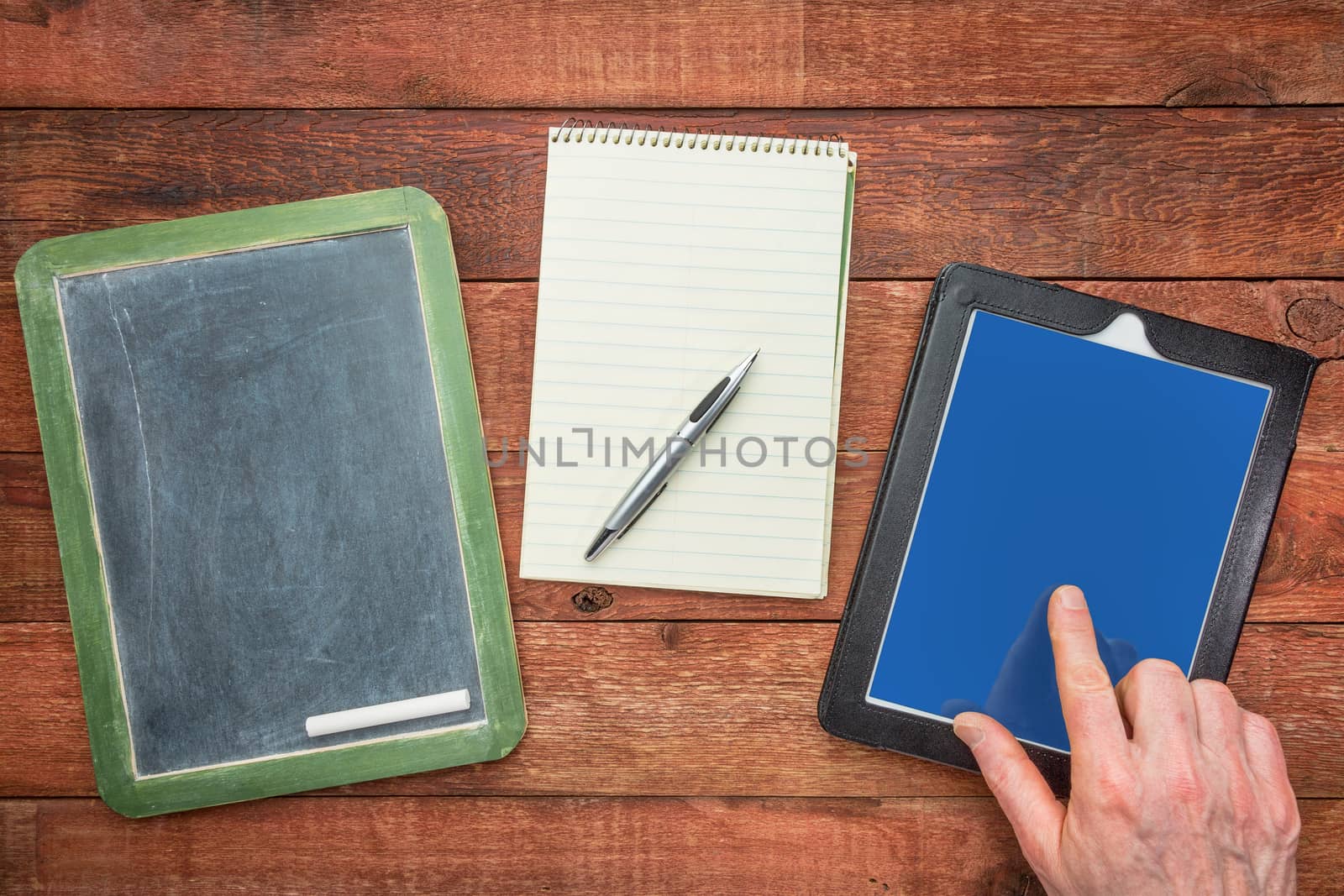 slate blackboard, with chalk, notepad with a pen and digital tablet with a finger - generations of making notes concept