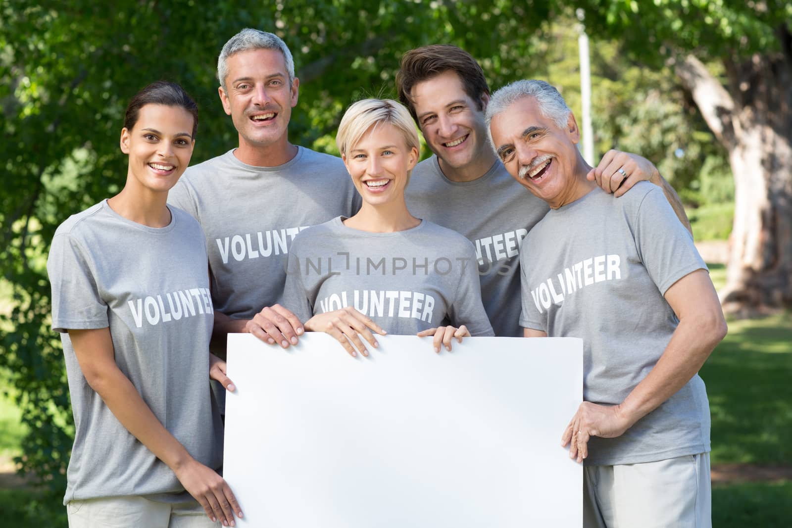 Happy volunteer family holding a blank on a sunny day