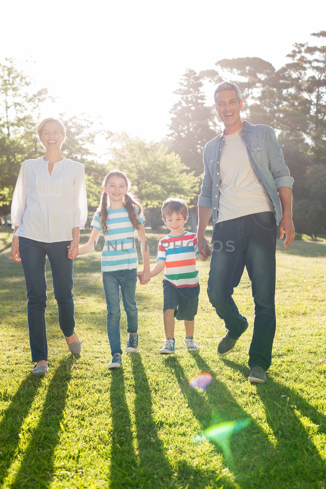 Happy family walking at the park on a sunny day 