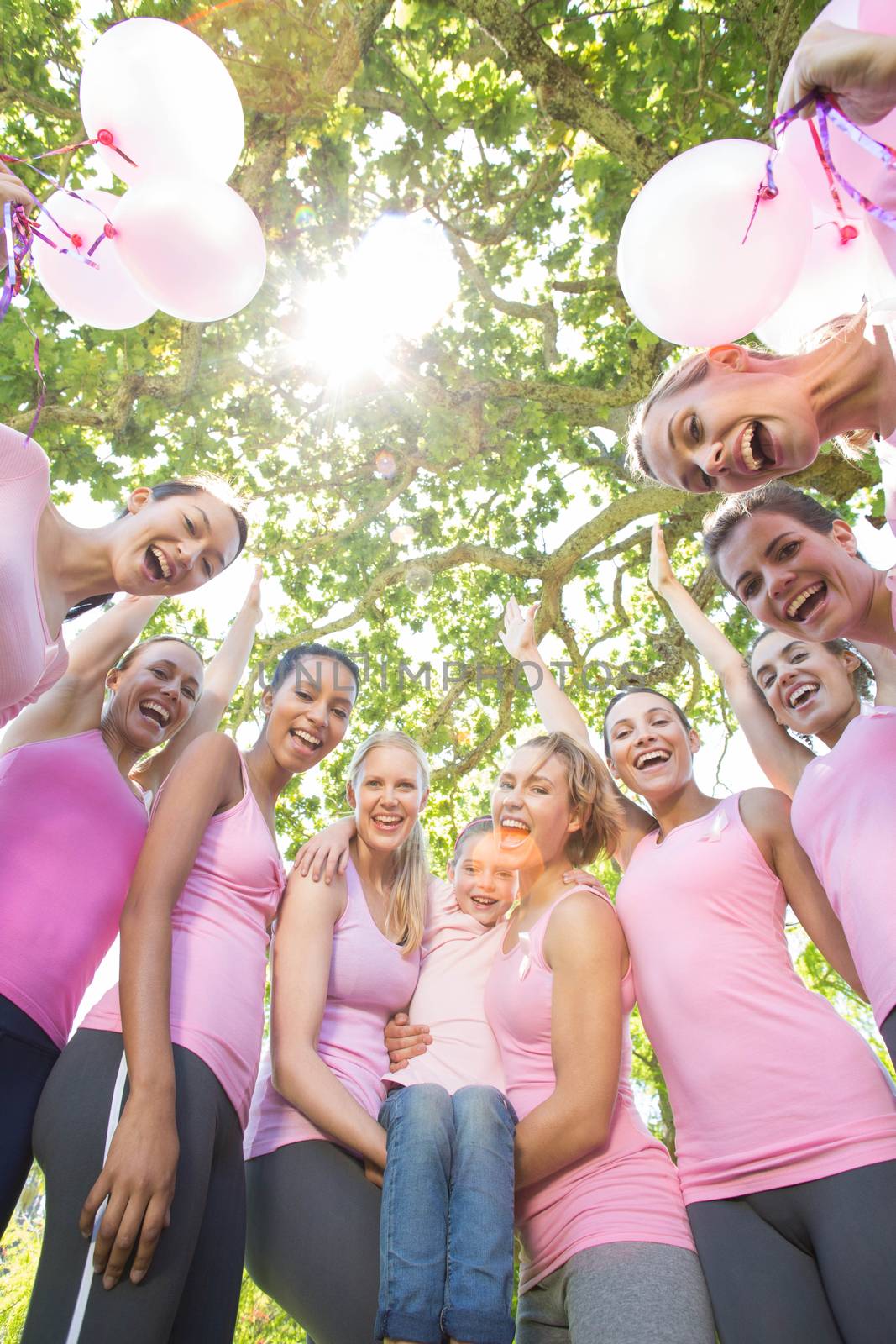Smiling women in pink for breast cancer awareness on a sunny day