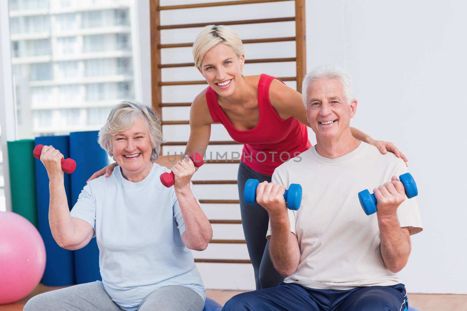 Happy female trainer with senior couple by Wavebreakmedia