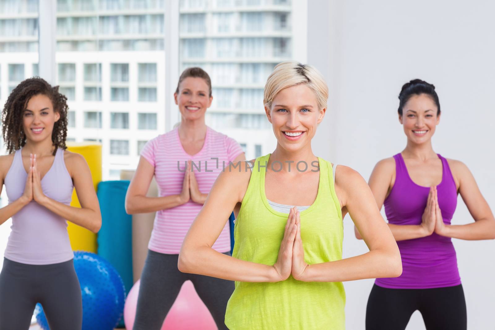 Women with hands joined exercising at gym by Wavebreakmedia
