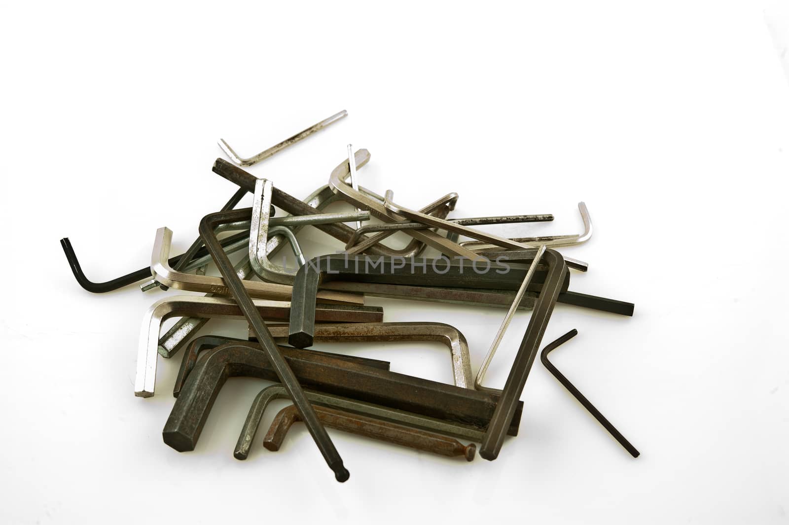 
Pile of hexagon wrenches stacked in a row, or sprinkled on the white paper