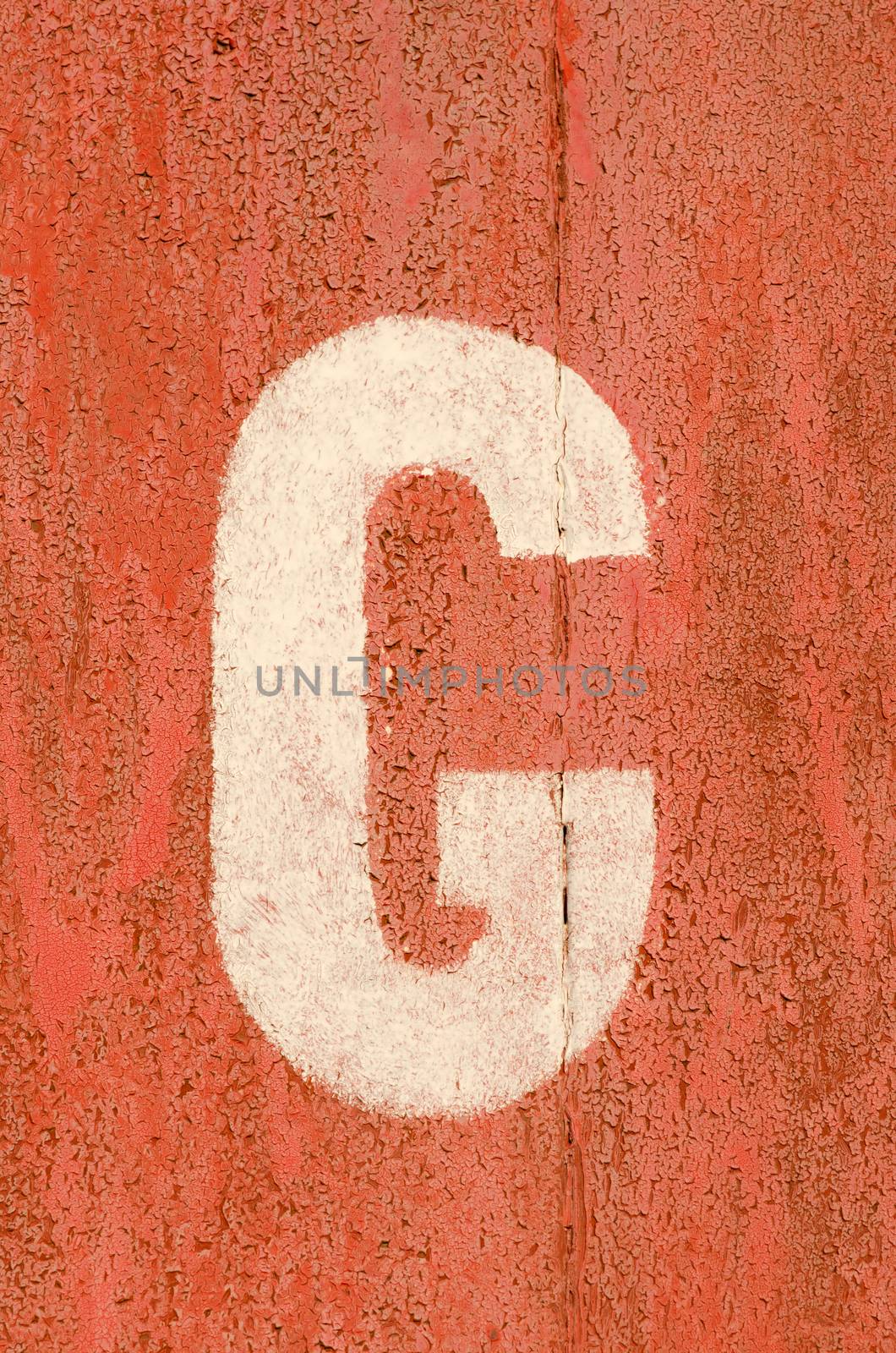 Letter painted on old rusty iron wall of garage.