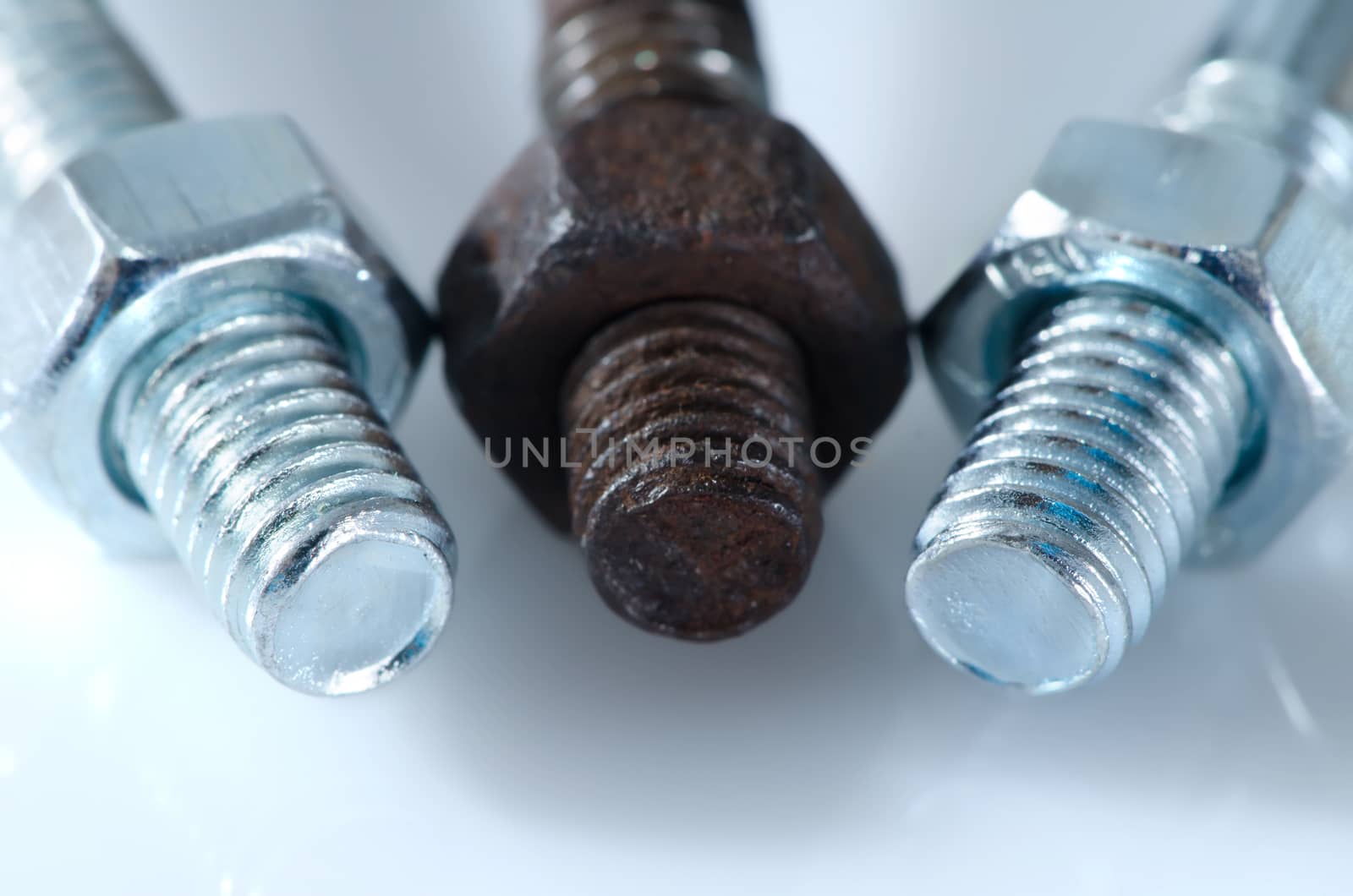 One old rusty screw among two new screws.