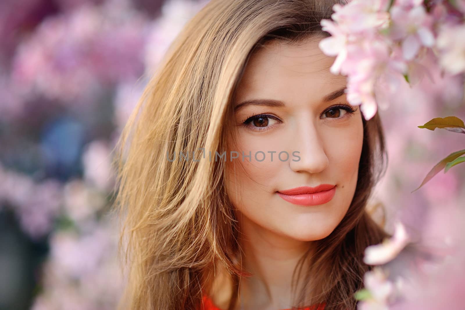 Beautiful woman among spring blossom.