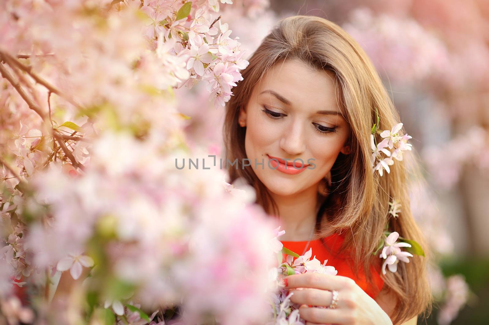 Portrait of beautiful woman near a flowering tree.