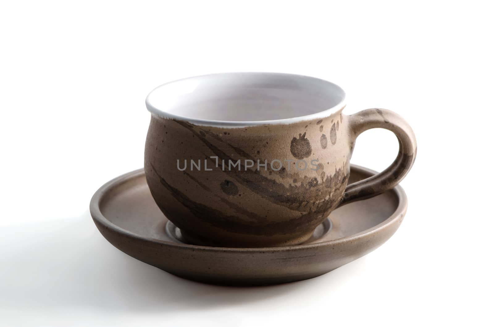 Brown ceramic cup and saucer isolated on white background, applied art.  