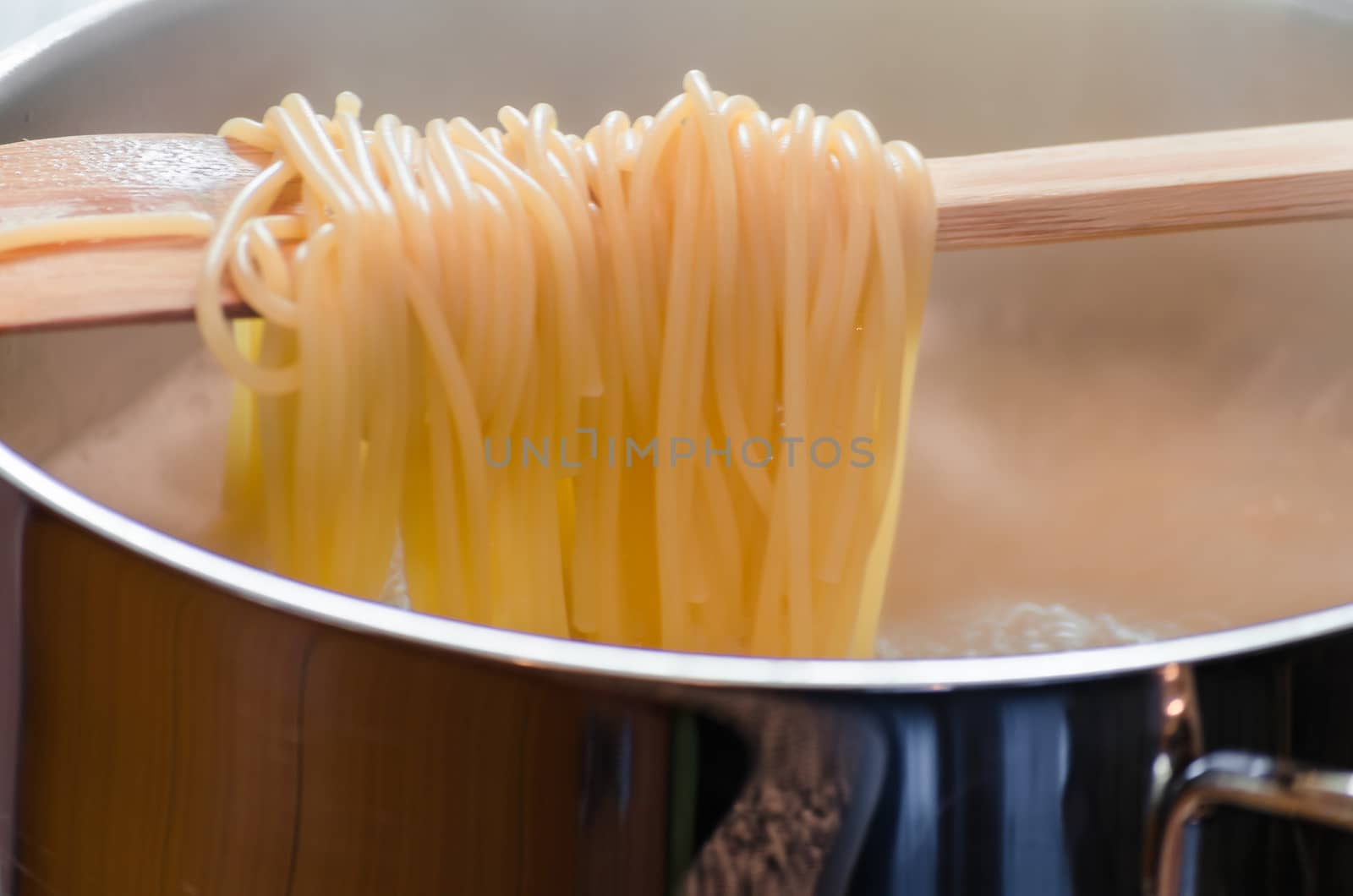 View in a saucepan with a wooden spoon hanging over the spaghetti.