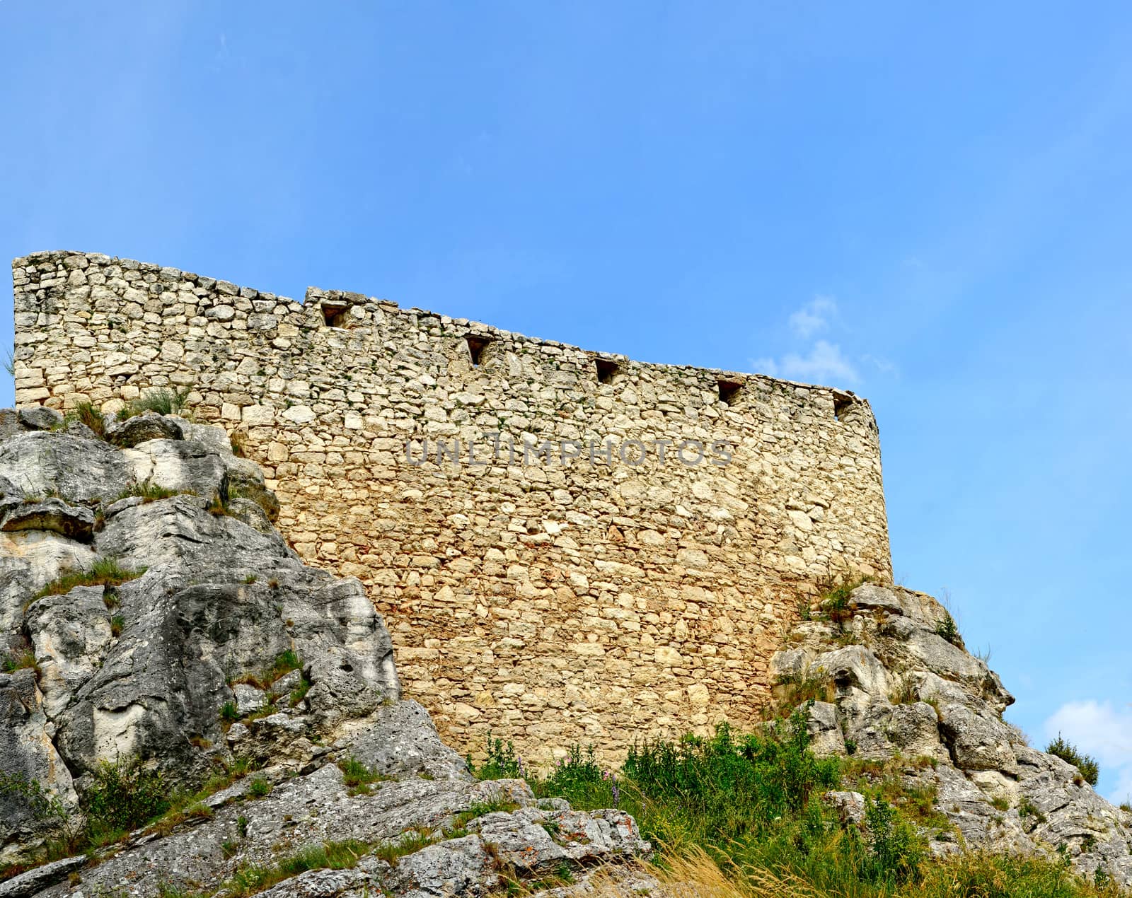 Old castle wall on the top of rock.