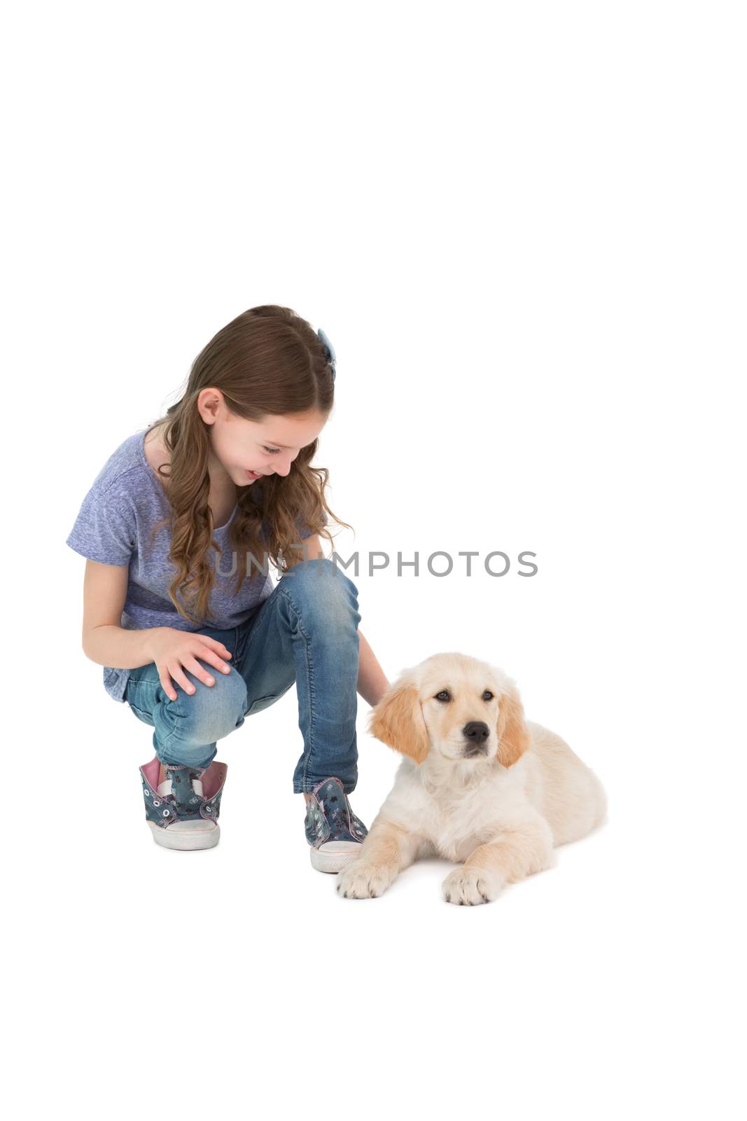 Crouching little girl next dog on white background
