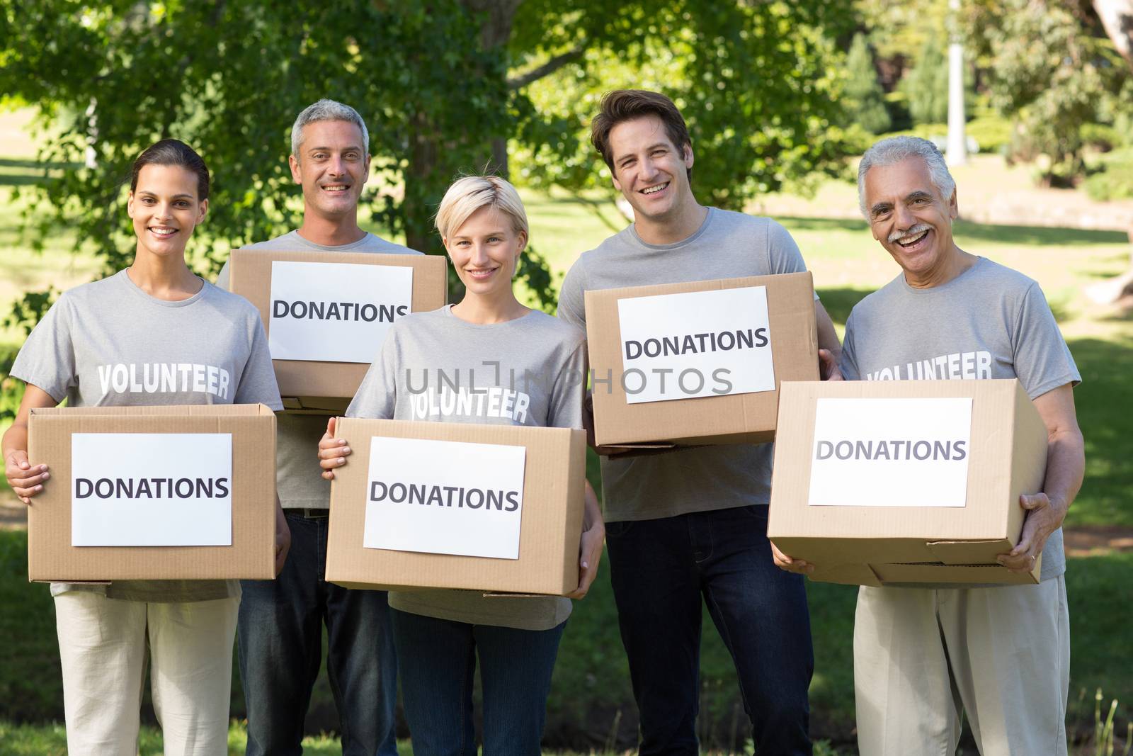 Happy volunteer family holding donations boxes  by Wavebreakmedia