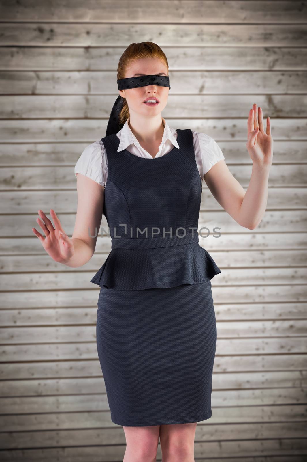 Redhead businesswoman in a blindfold against wooden planks background