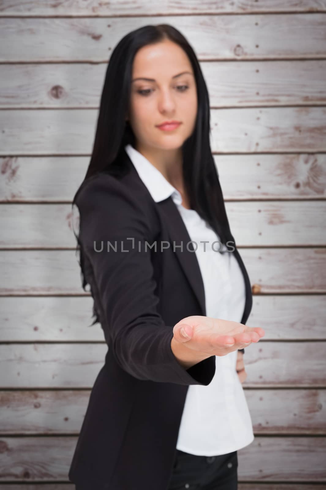 Composite image of pretty businesswoman presenting with hand by Wavebreakmedia