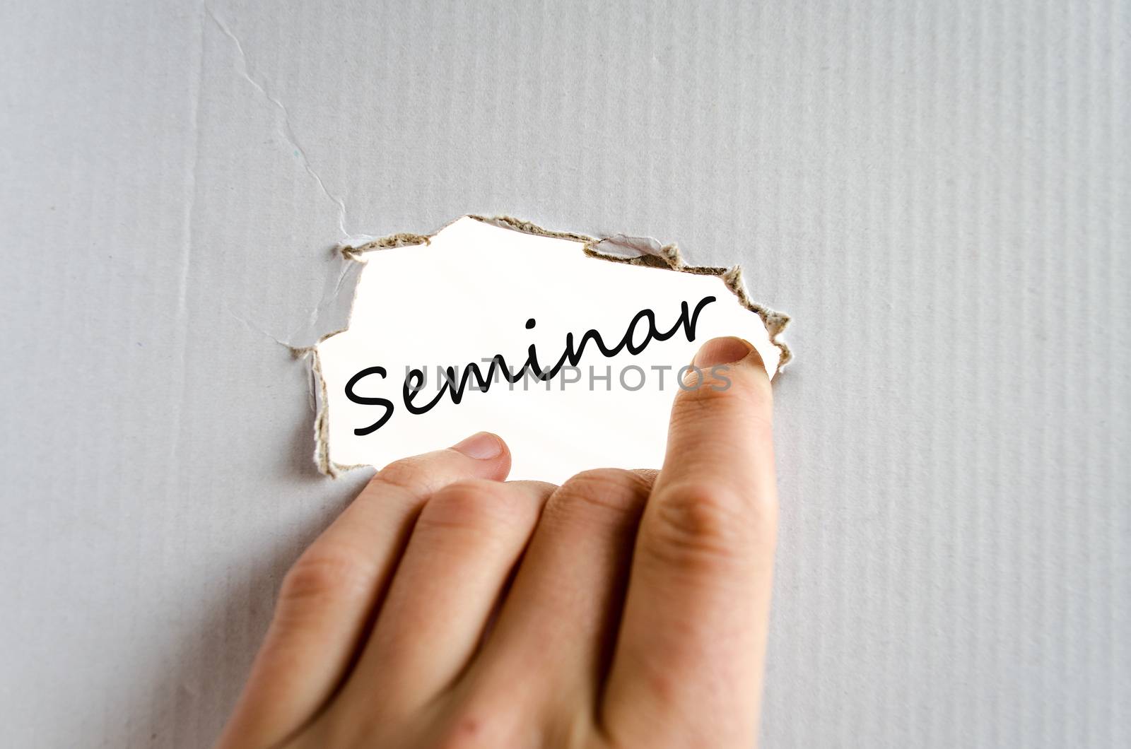 Hand on the cardboard background seminar concept